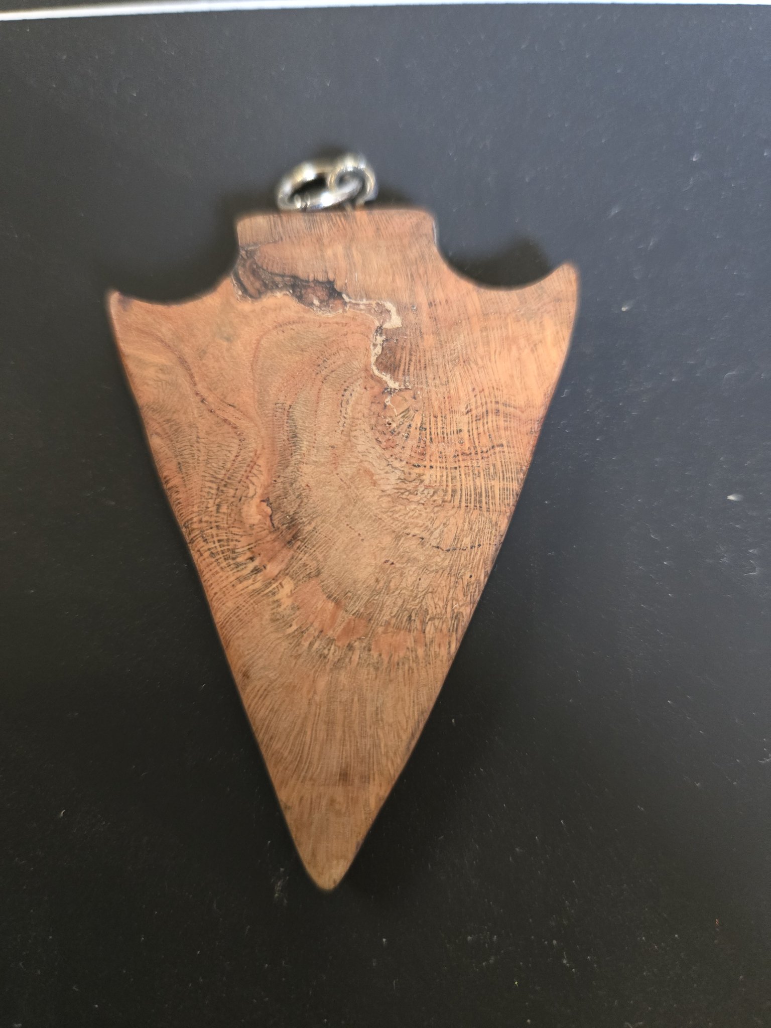 Back of the English walnut arrowhead pendant showing the natural wood grain