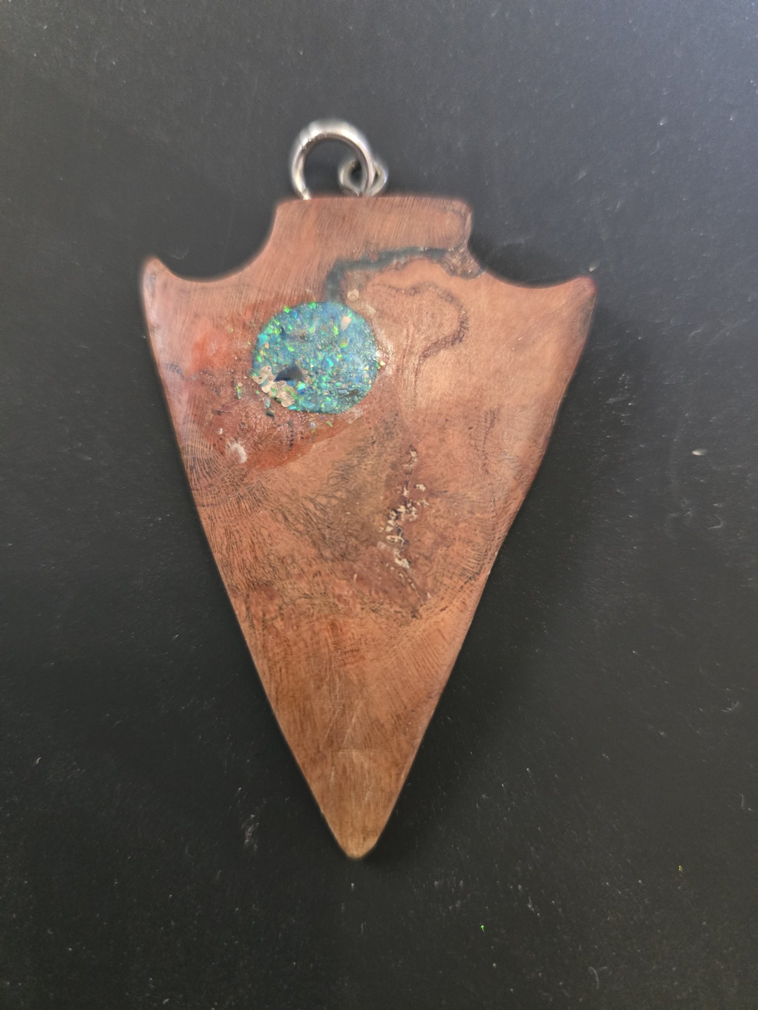 Closer front view of the blue opal inlay shimmering in the walnut pendant