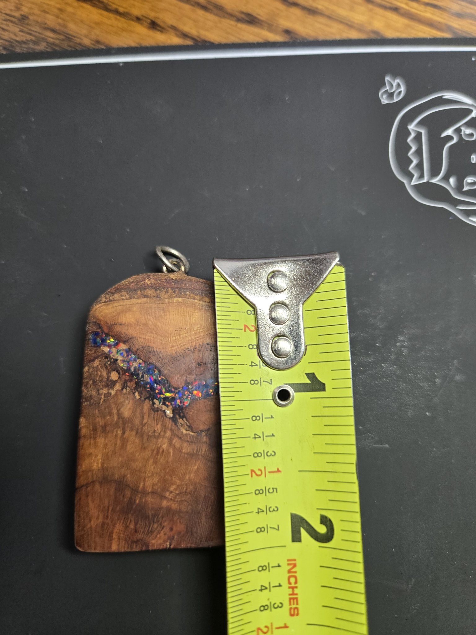 Spalted maple pendant beside a tape measure showing it is about two and a half inches long