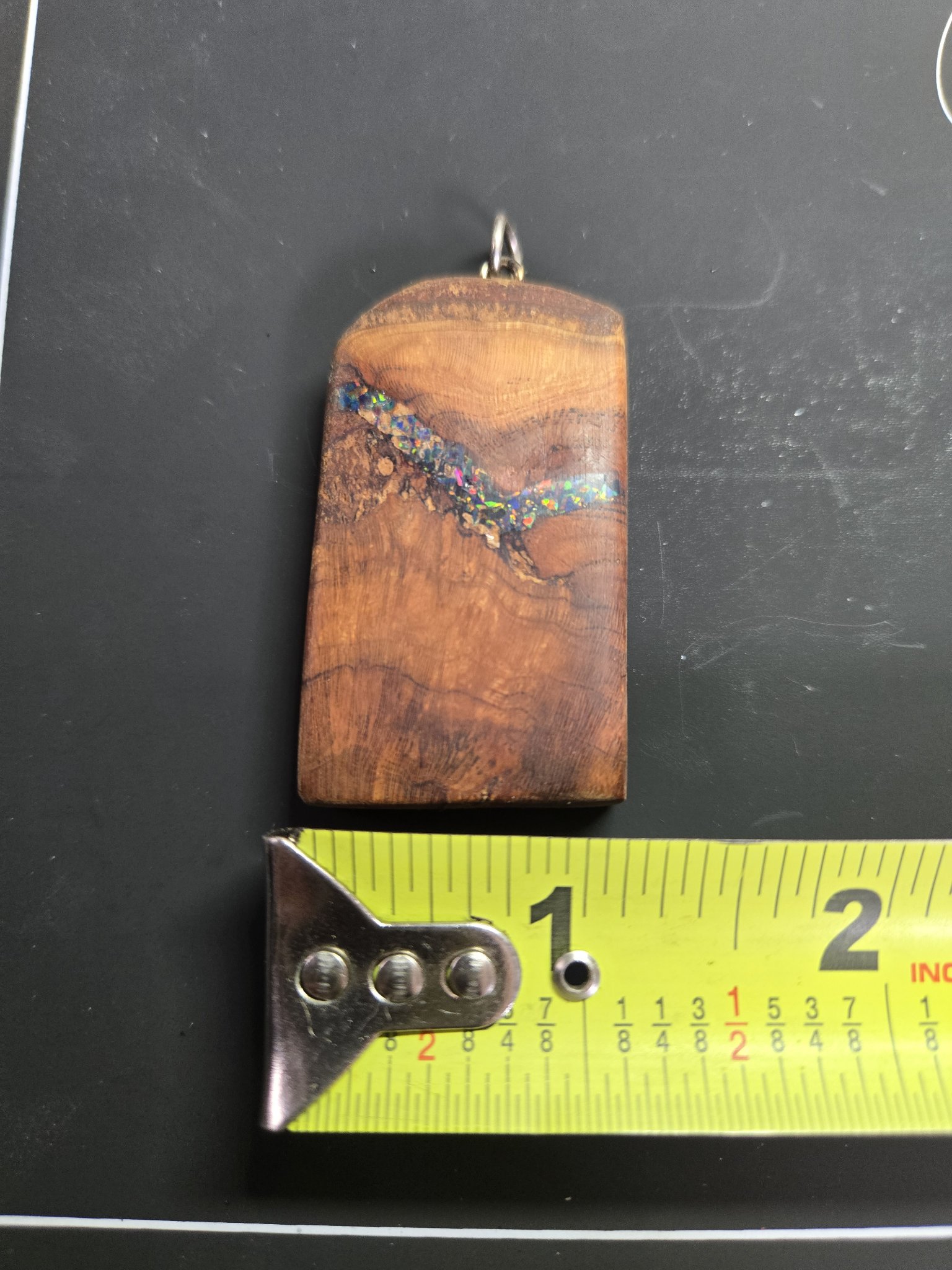 Front of the spalted maple pendant above a tape measure showing its width