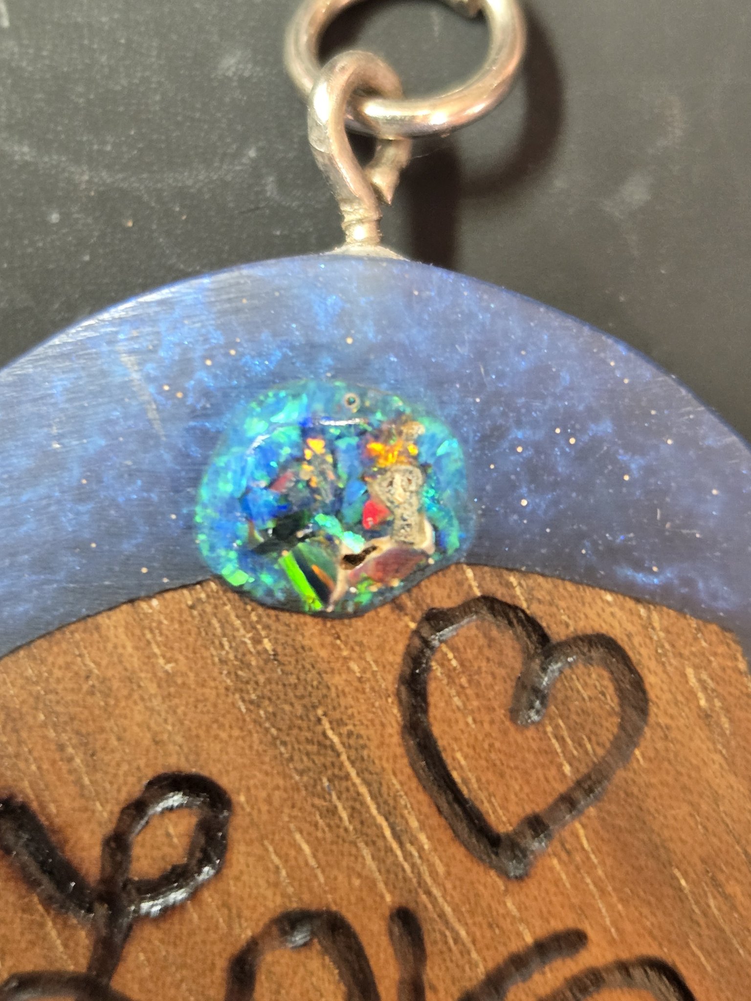 Close-up of the colorful fire opal cabochon set in blue resin