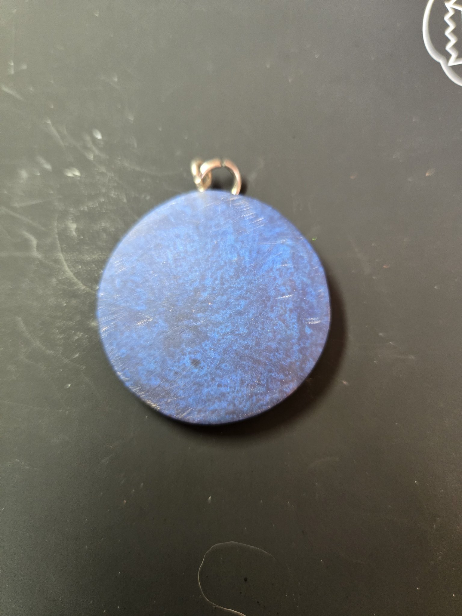 Back of the round pendant showing the blue resin finish