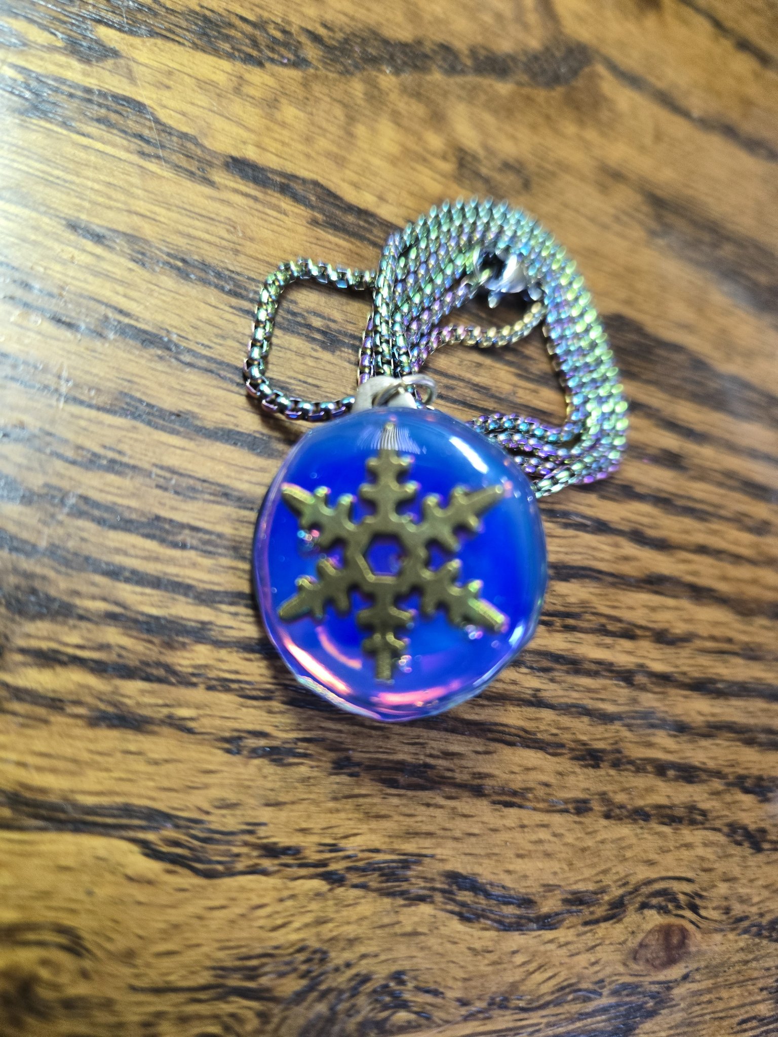 Reverse side of the blue and pink holographic resin pendant featuring a metal snowflake charm