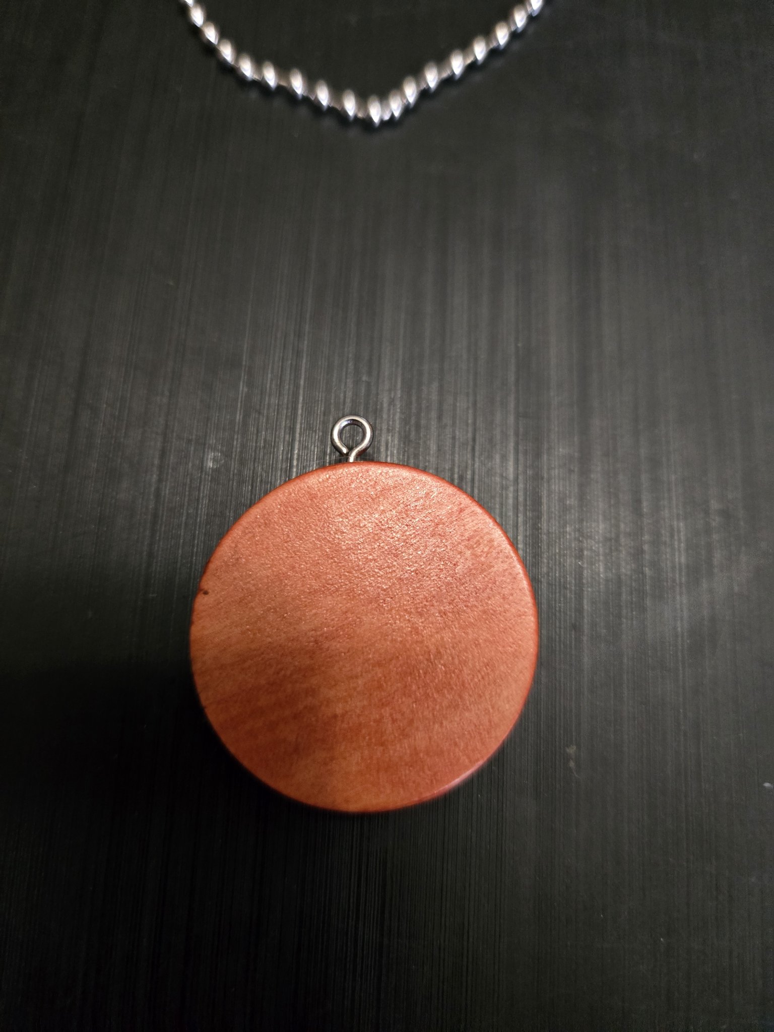 Back view of the round pendant showing the natural wood grain