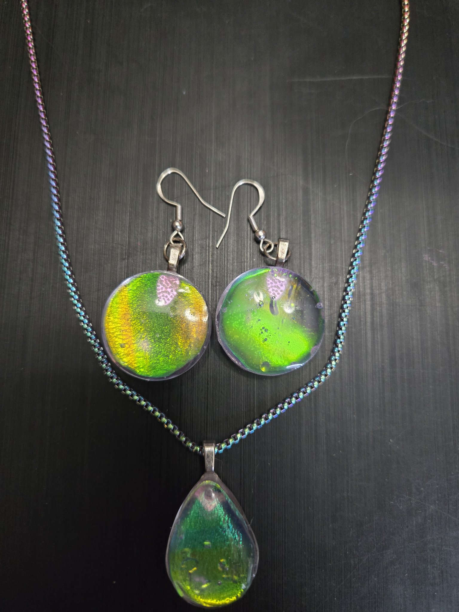 Alternate angle of the green-gold holographic earring and pendant set
