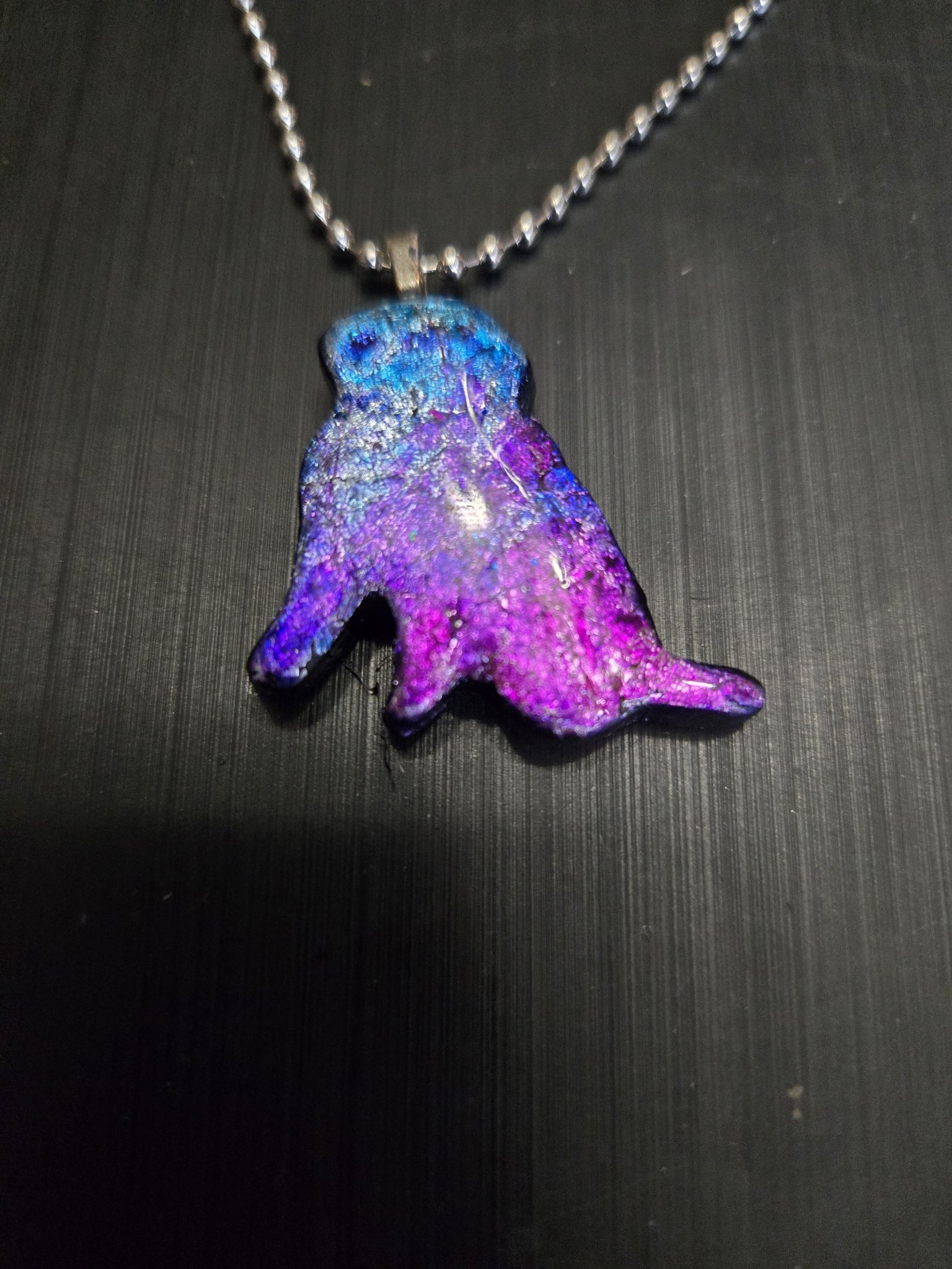 Front view of the dog-shaped pendant on its 22-inch silver-tone ball chain