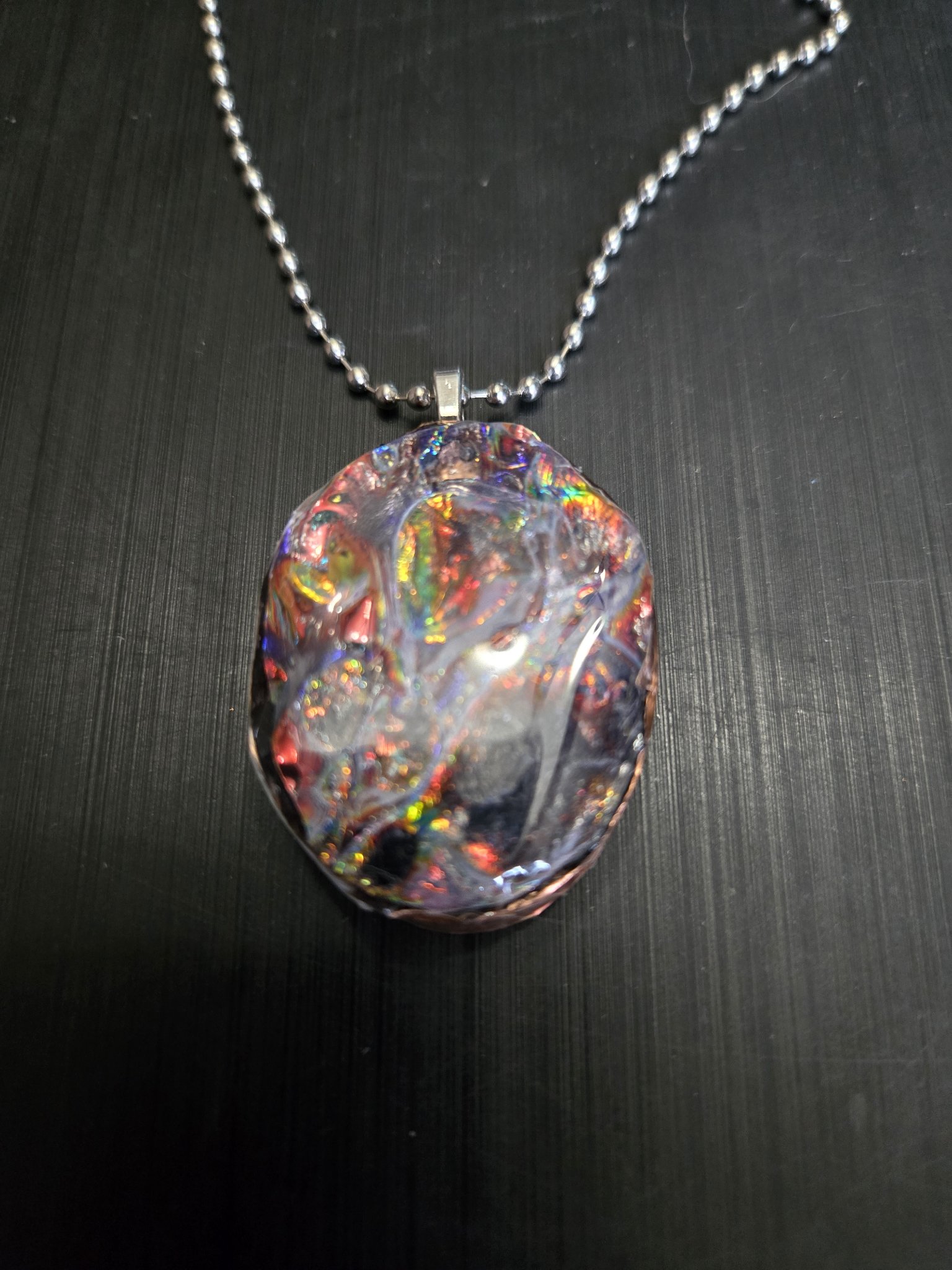 Colorful holographic resin front of the oval double-sided steampunk pendant with a copper rim on its 22-inch ball chain