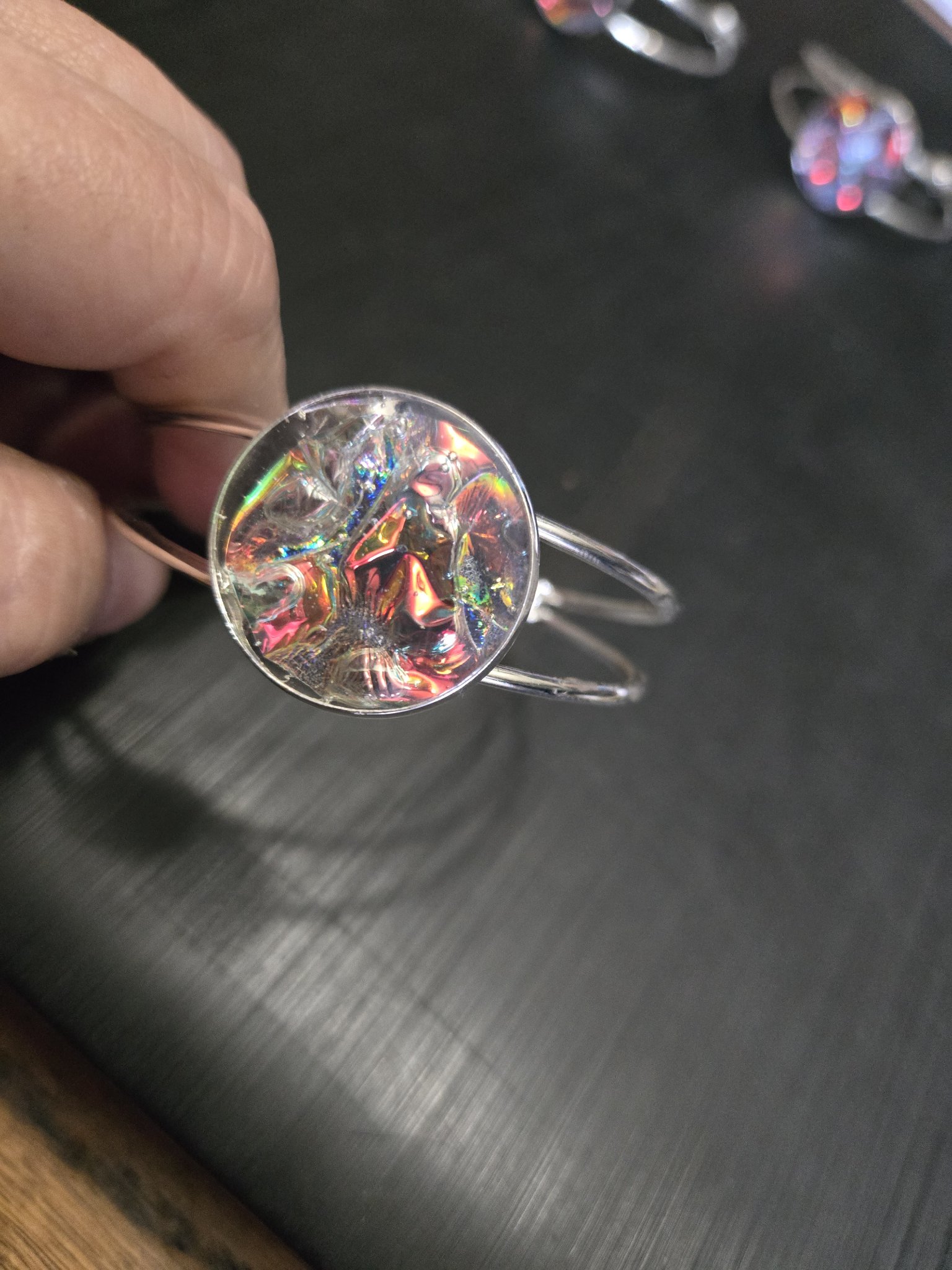 Alternate angle of the silver-tone adjustable cuff and plain holographic resin medallion