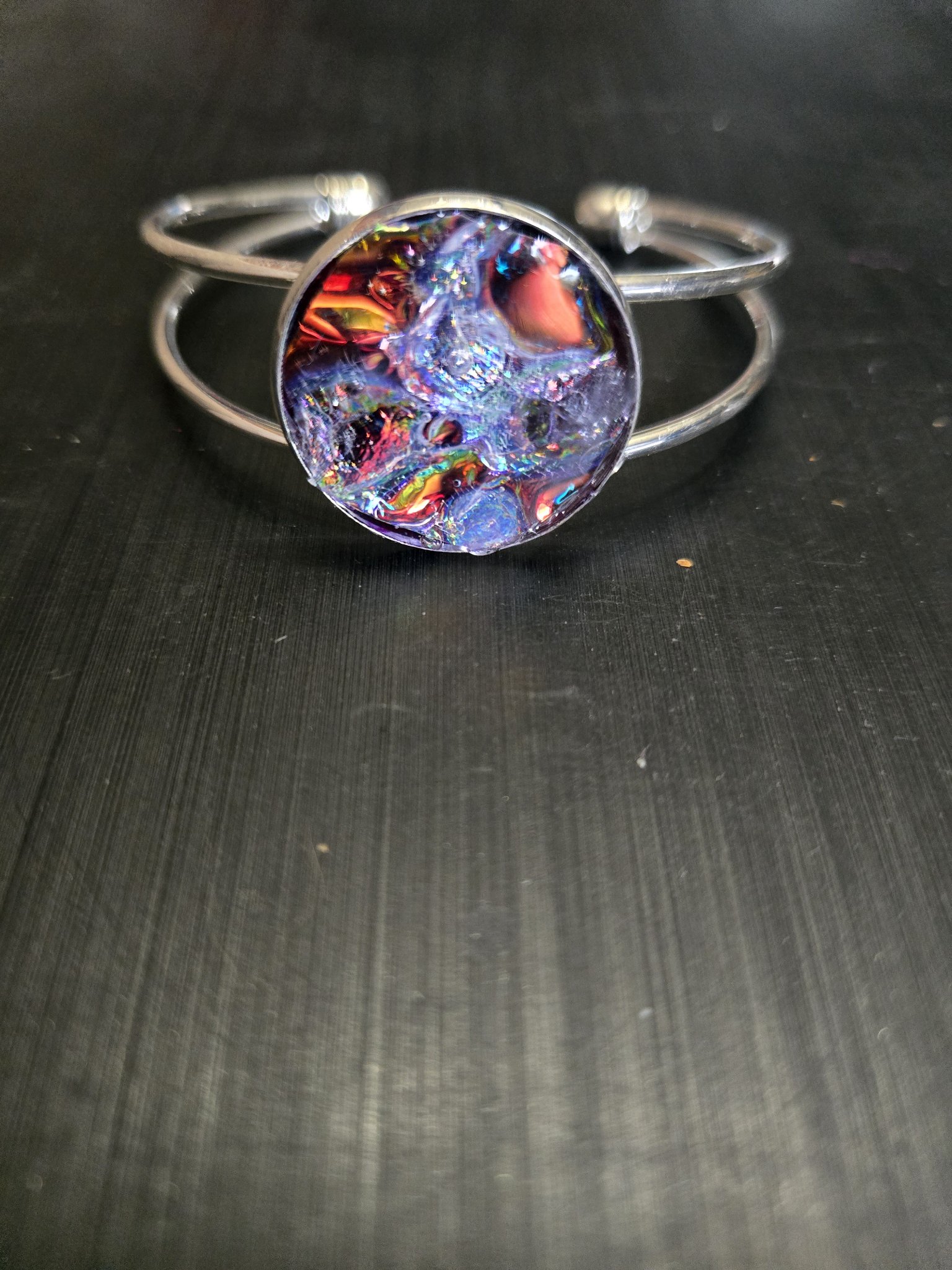 Alternate angle of stock 143 silver-tone adjustable cuff and plain holographic resin medallion