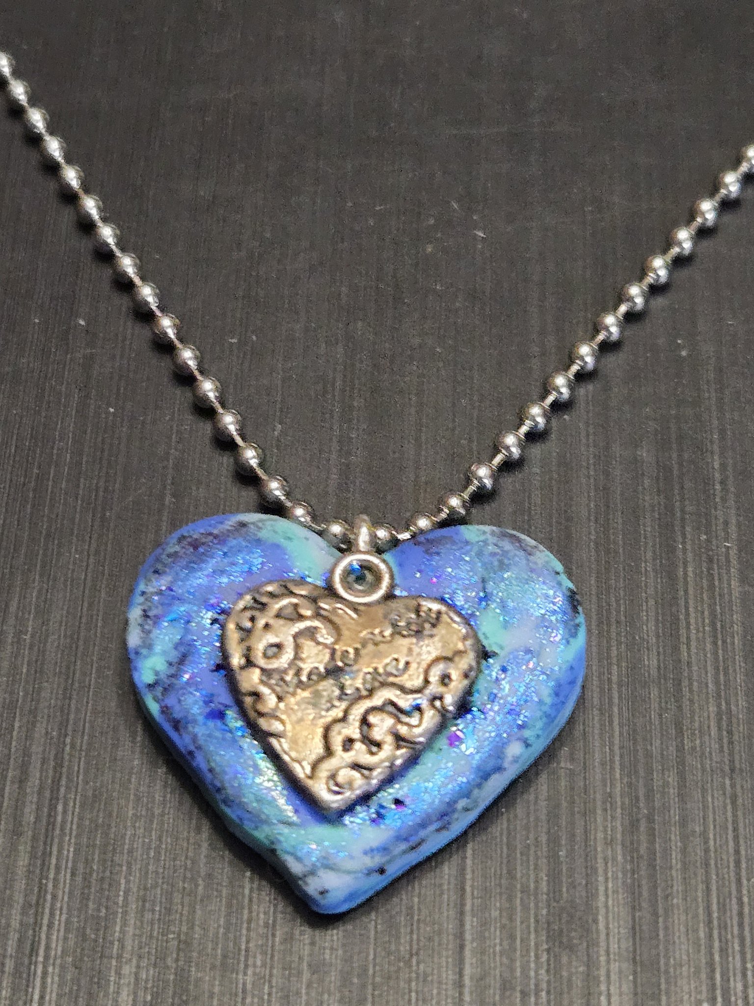 Close-up of stock 152 showing the blue iridescent polymer clay and brass-tone Made with love heart charm