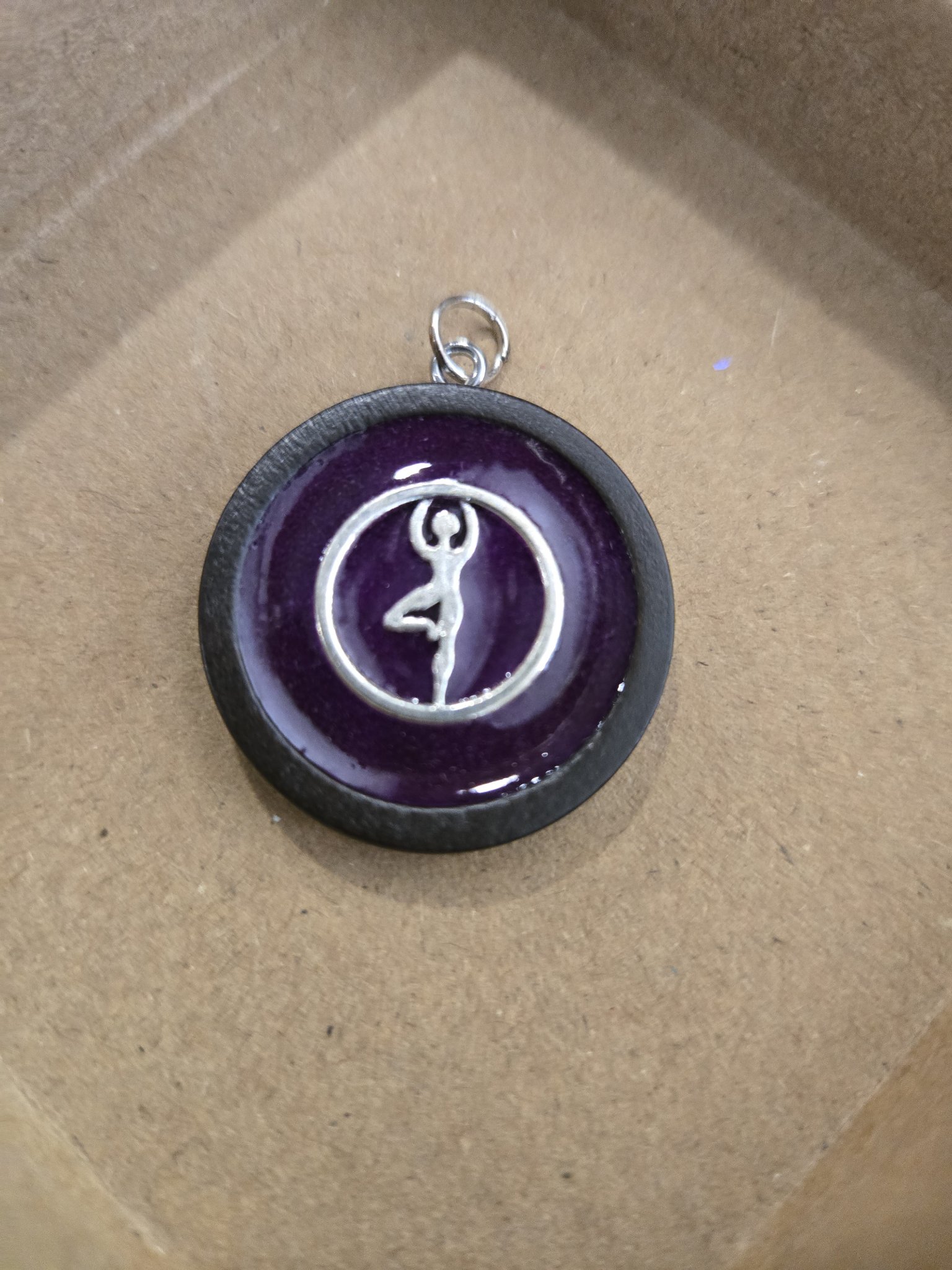 Stock 167 round wood and purple resin pendant with a silver-tone dancer in a circle charm in daylight
