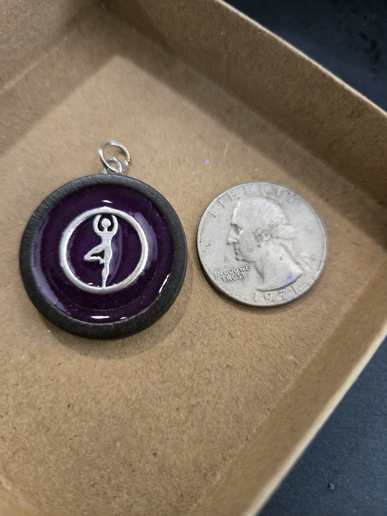 Stock 167 glow-in-the-dark dancer pendant beside a quarter for scale