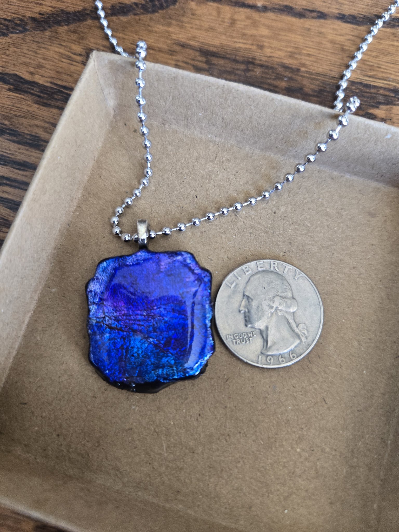 Stock 174 silver leaf and alcohol ink polymer clay pendant beside a quarter for scale