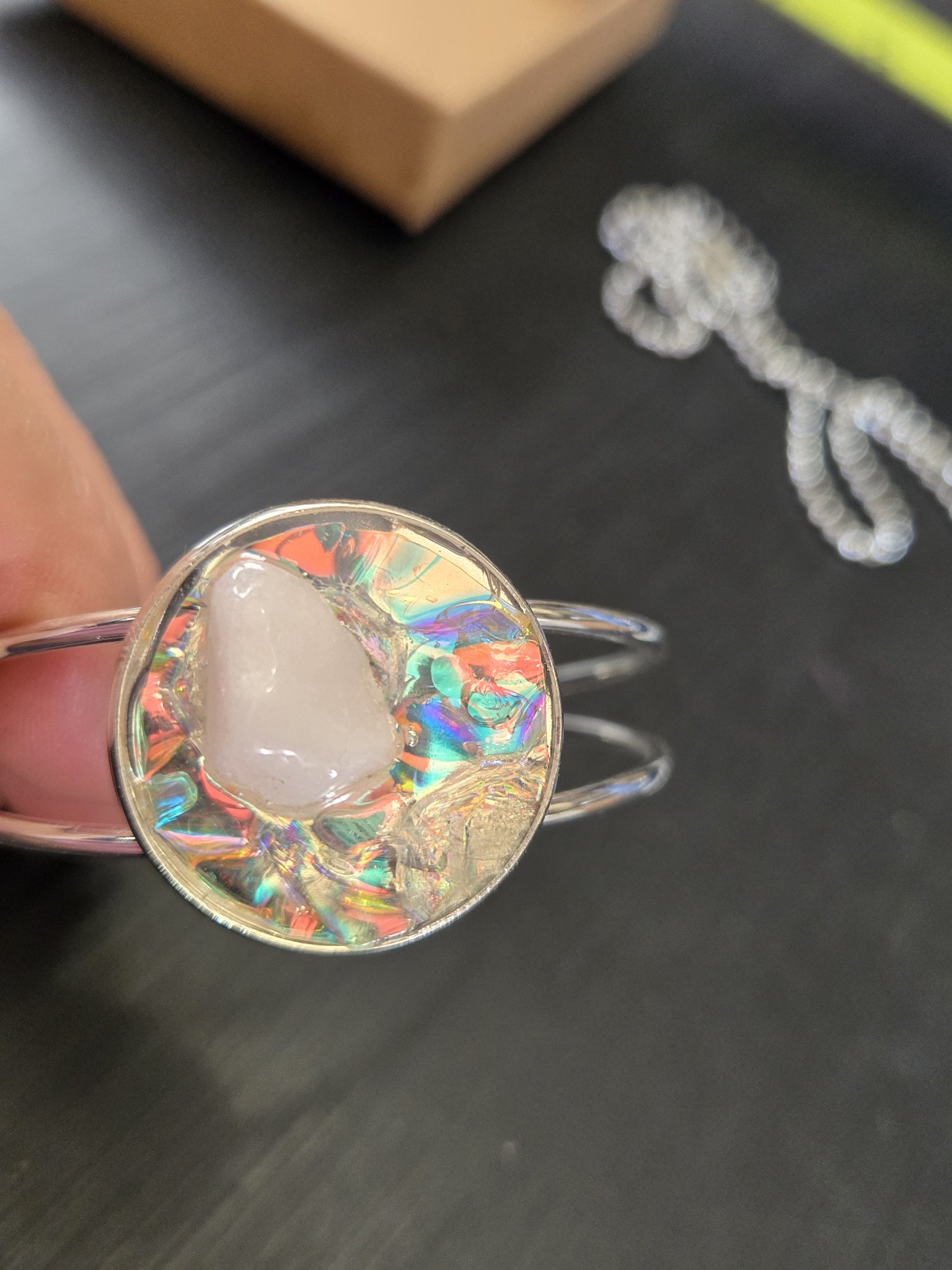 Close-up of the adjustable silver-tone cuff bracelet with quartz stone set in holographic resin from stock 184