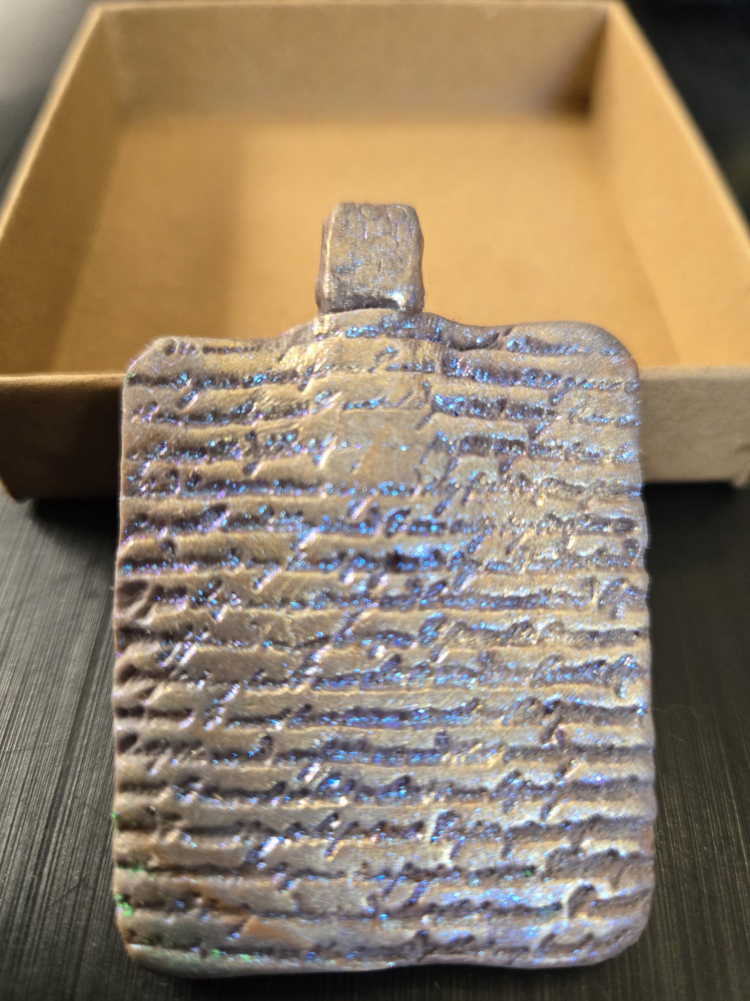 Textured back of stock 190 blue mica polymer clay pendant