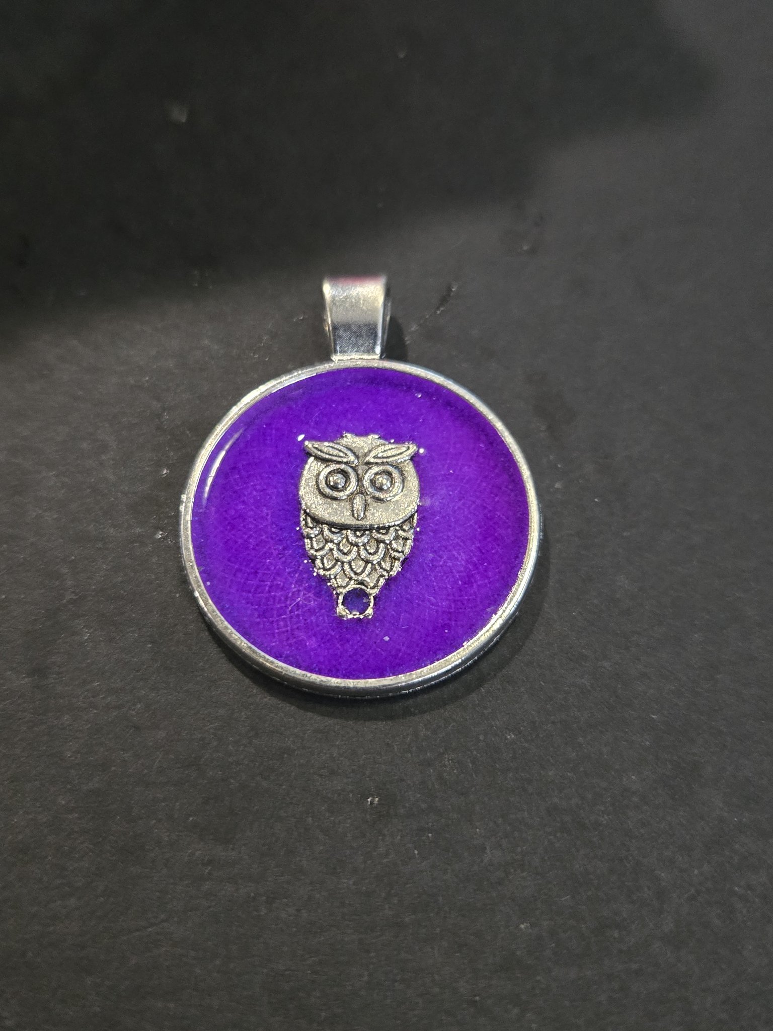Stock 200 round purple glow-in-the-dark owl resin pendant in a metal frame, shown from the front