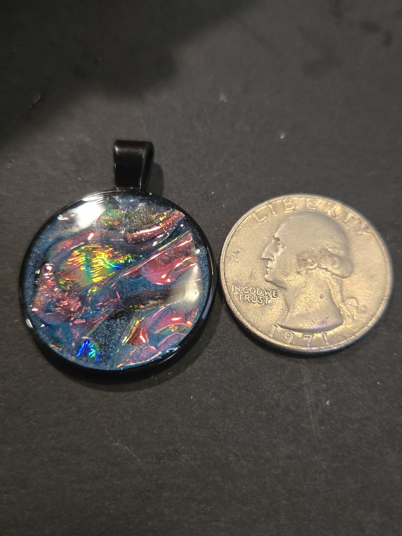 Front of stock 204 holographic resin pendant beside a quarter for scale