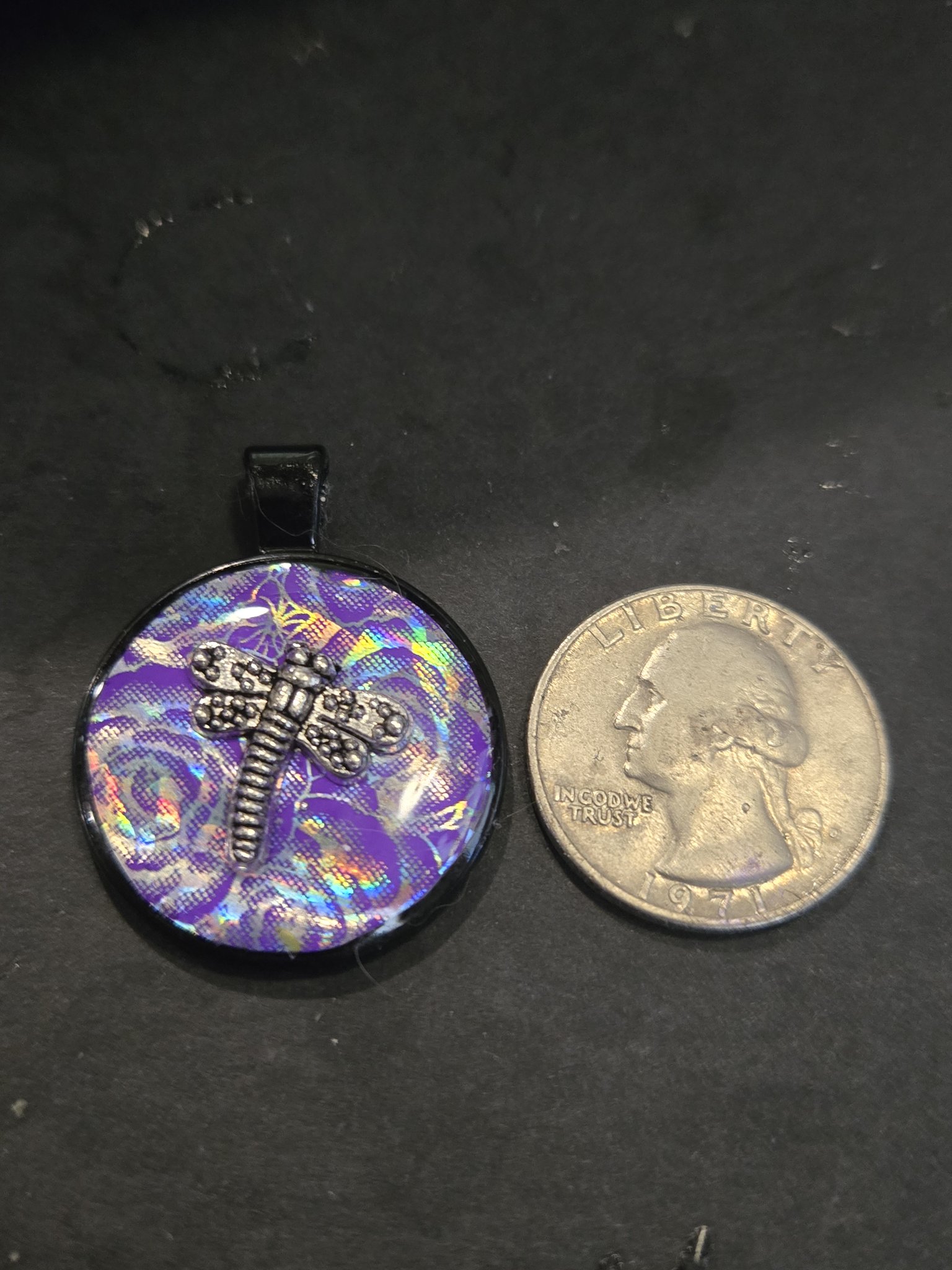 Front of stock 206 holographic dragonfly resin pendant beside a quarter for scale