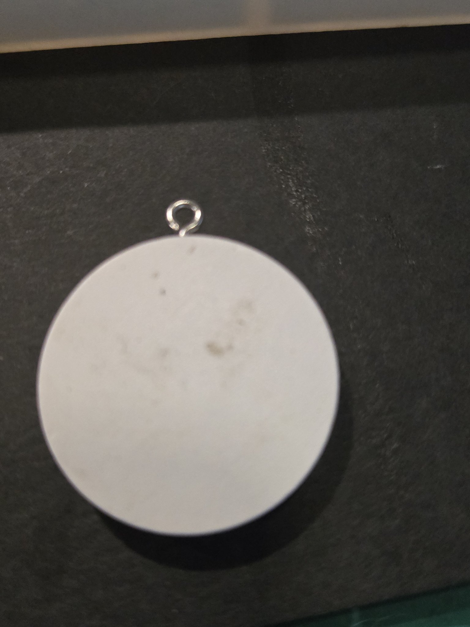 Back of stock 207 holographic handmirror resin pendant in its white wood frame