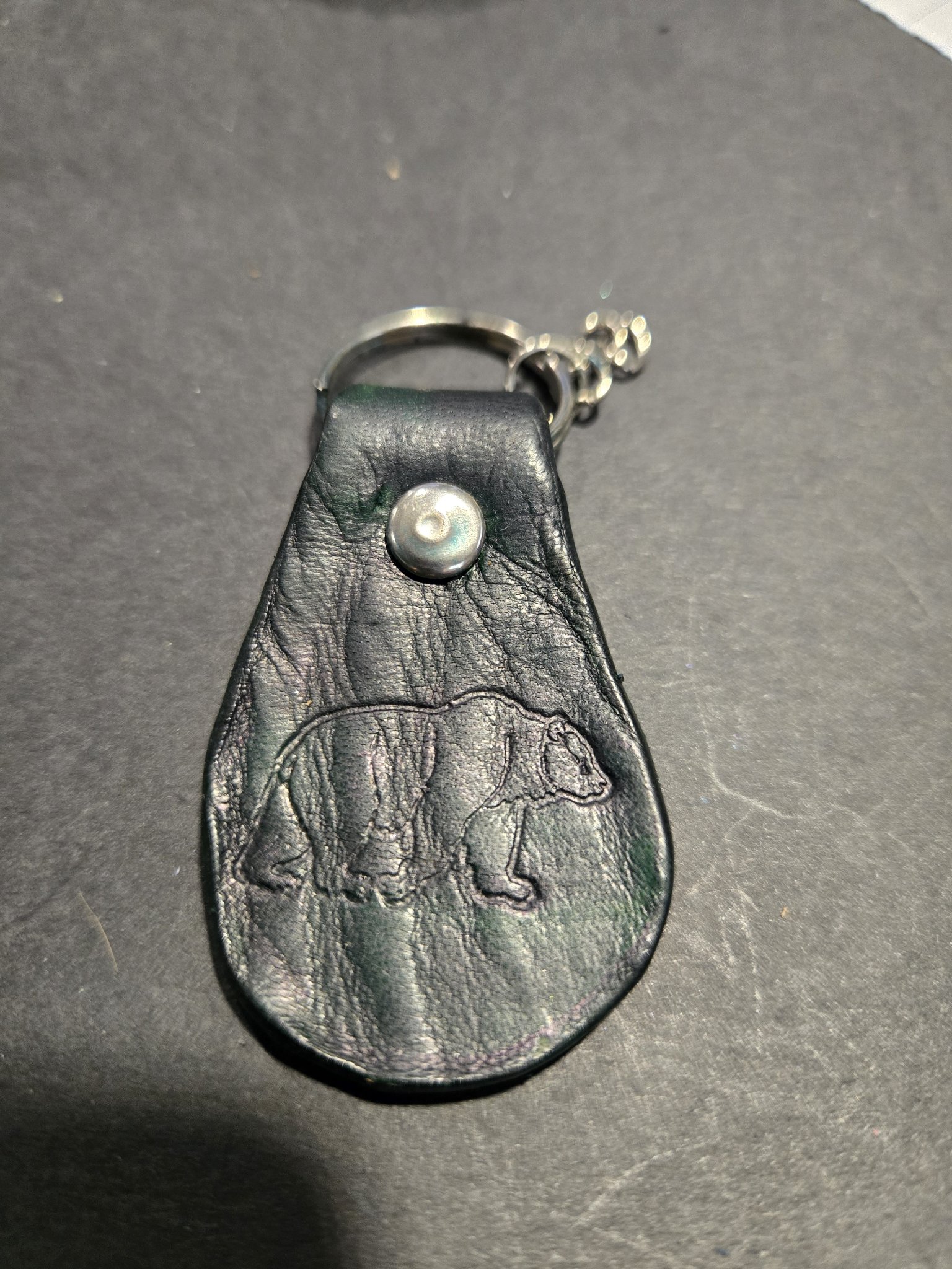 Stock 233 dark green leather keychain with an embossed grizzly bear, shown with its silver-tone rivet and split key ring