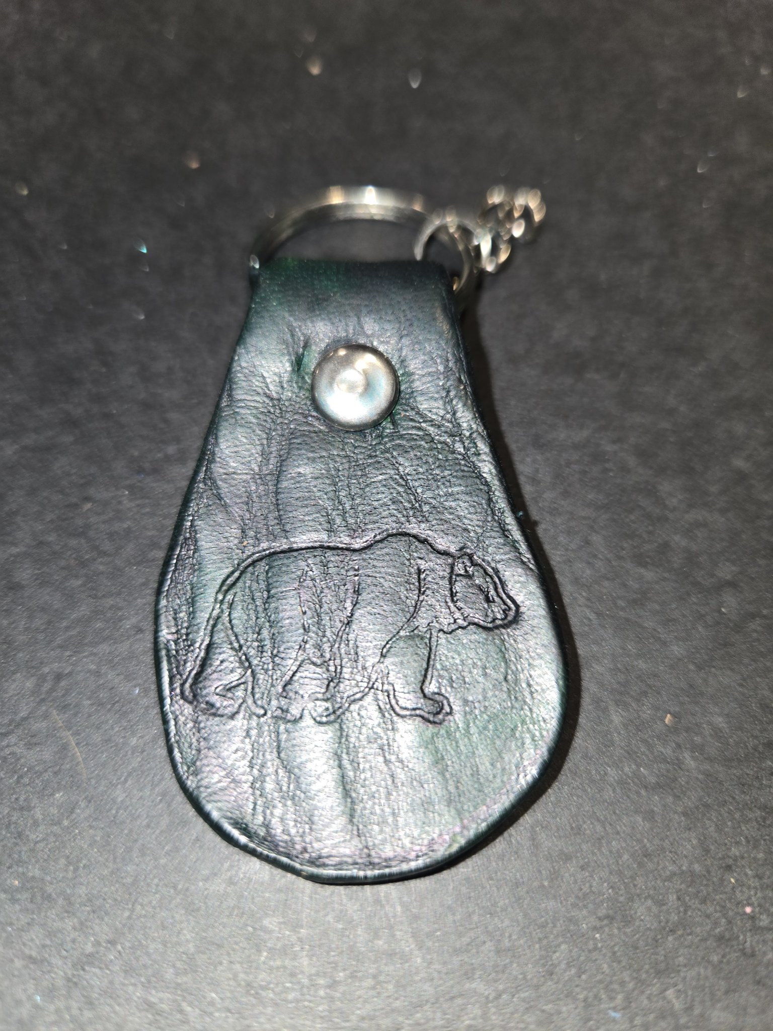 Close-up of stock 233 showing the embossed grizzly bear on the dark green leather