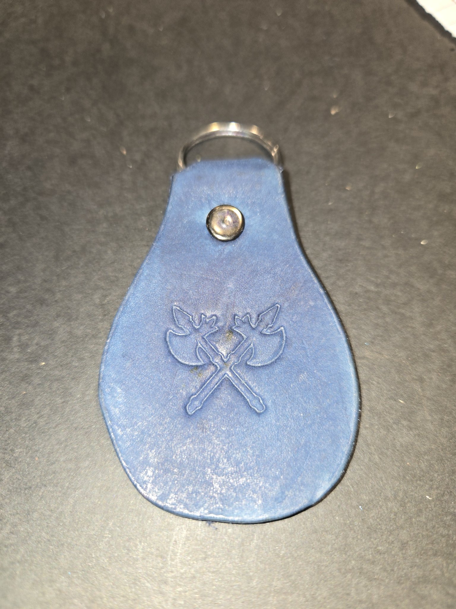 Stock 234 blue leather keychain with embossed crossed axes, shown with its silver-tone rivet and split key ring