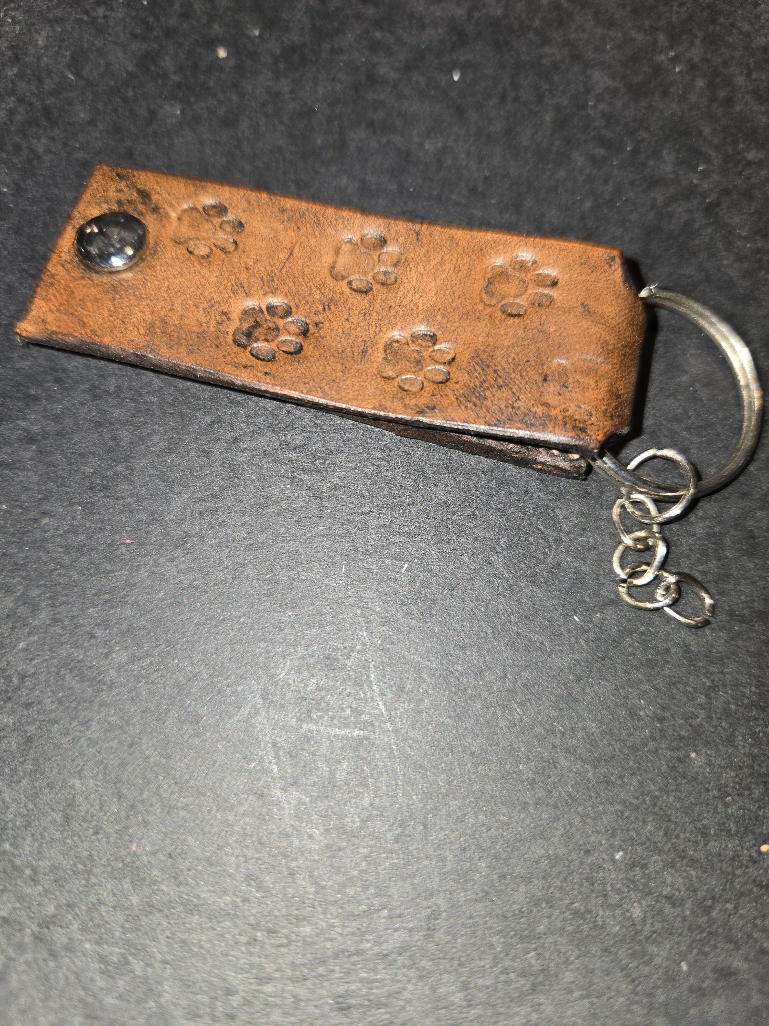 Side view of stock 237 showing the folded brown leather strap and the short chain on the split key ring