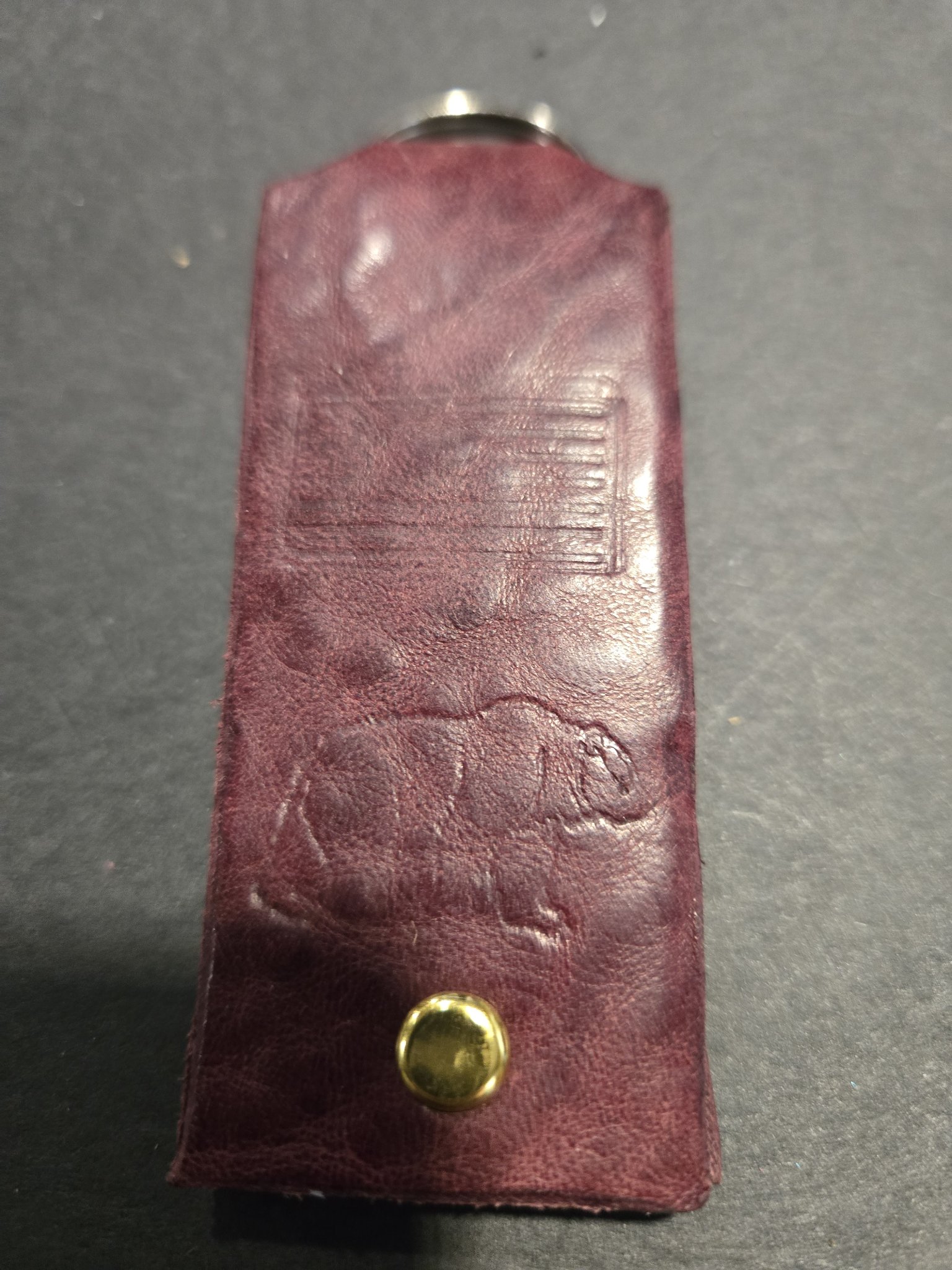 Angled view of stock 238 showing the hand-stamped grizzly bear and American flag in the maroon leather