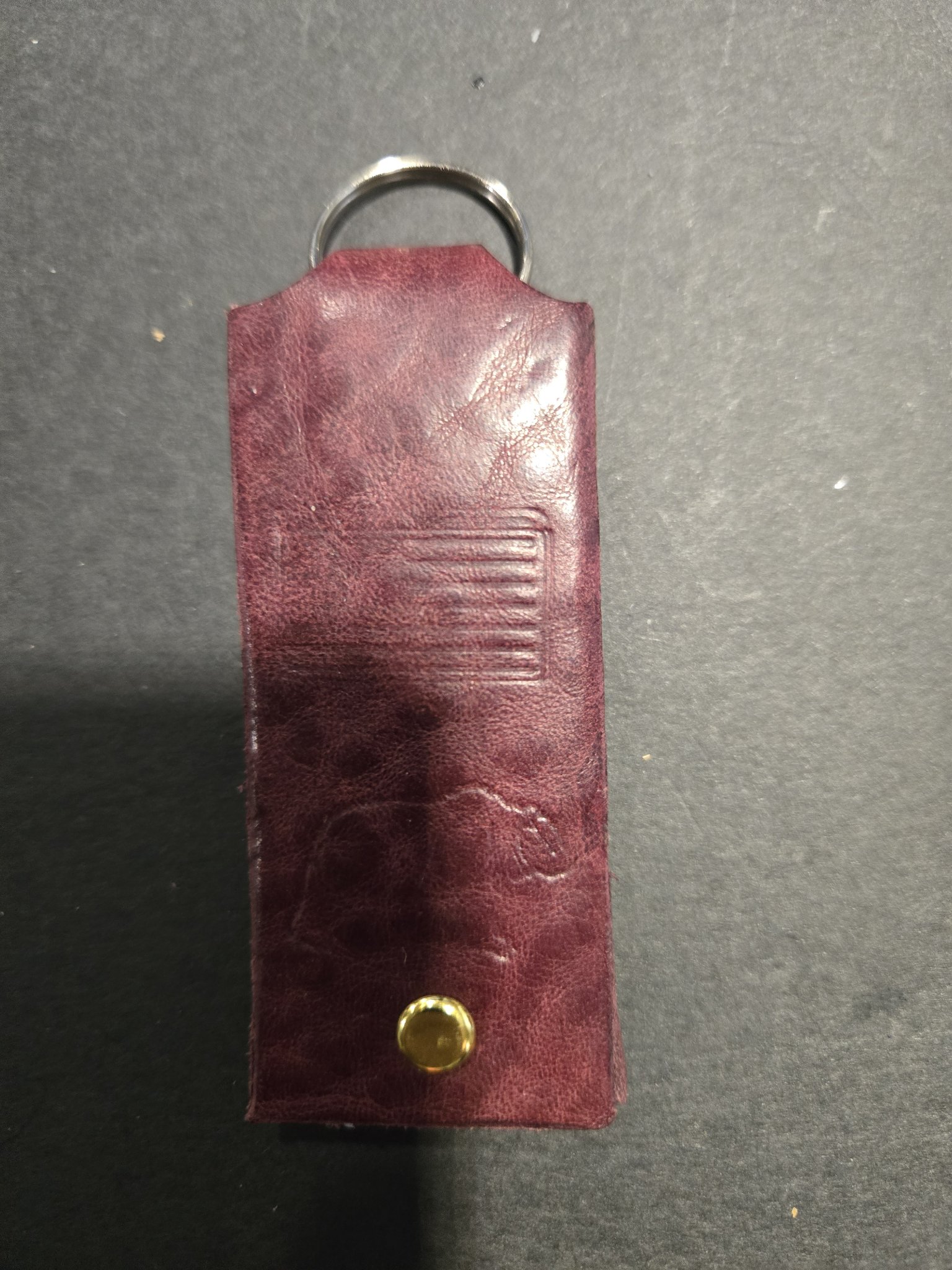 Back view of stock 238 showing the maroon leather strap, gold-tone rivet, and split key ring