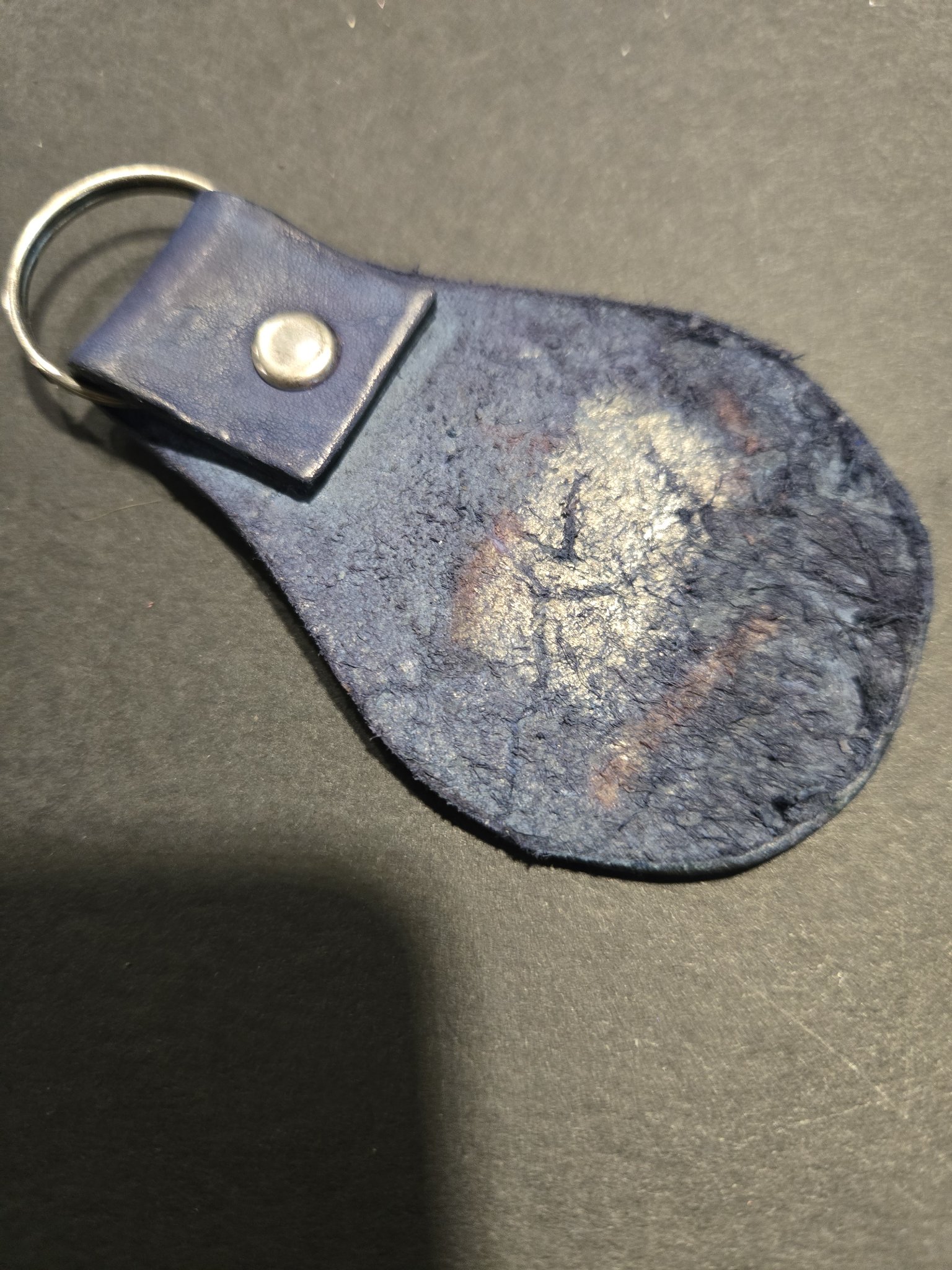 Back view of stock 239 showing the dark blue leather, silver-tone rivet, and split key ring