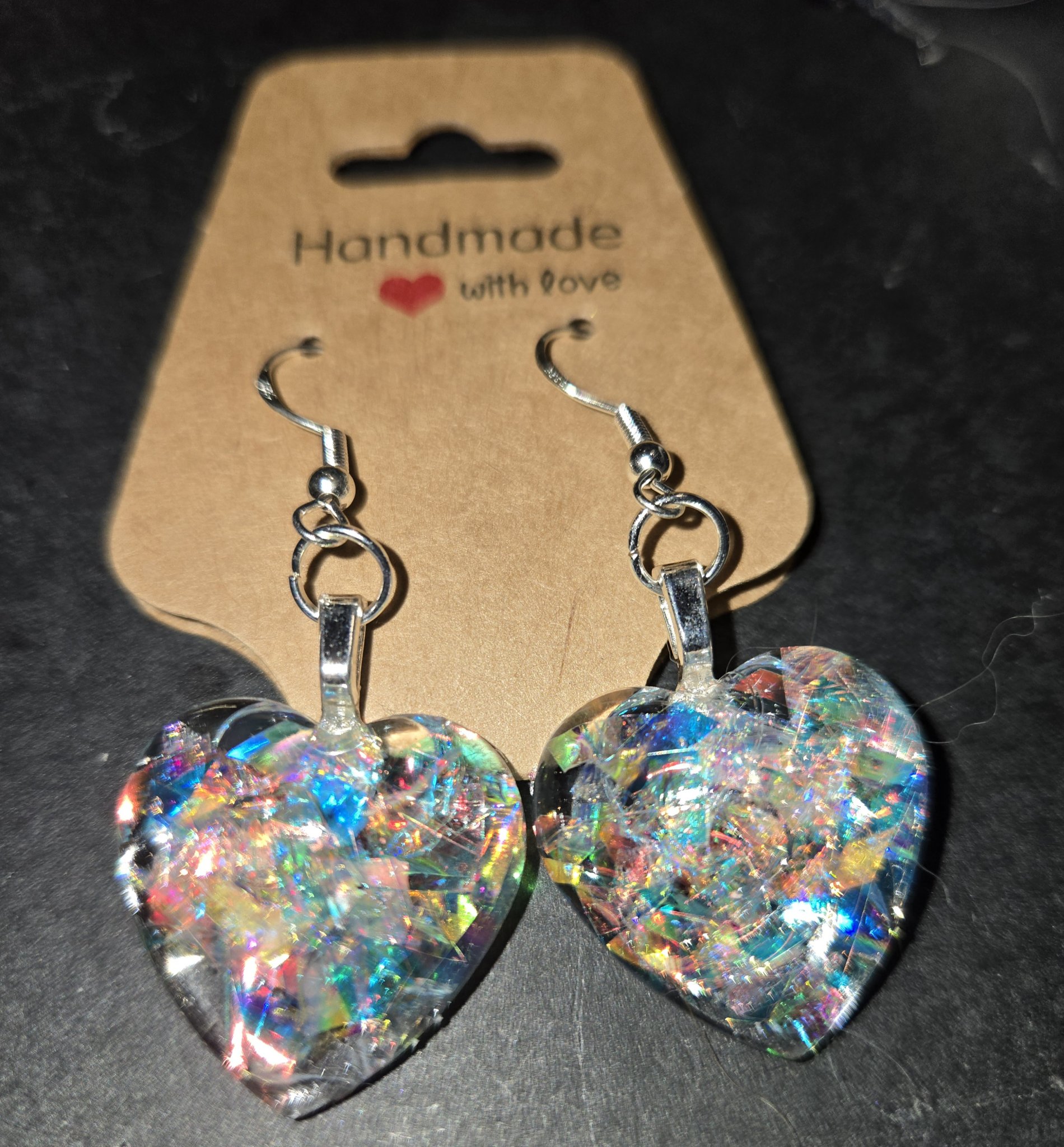Stock 246 holographic heart earrings on a handmade card, showing the rainbow sparkle in both acrylic hearts and the sterling silver wires