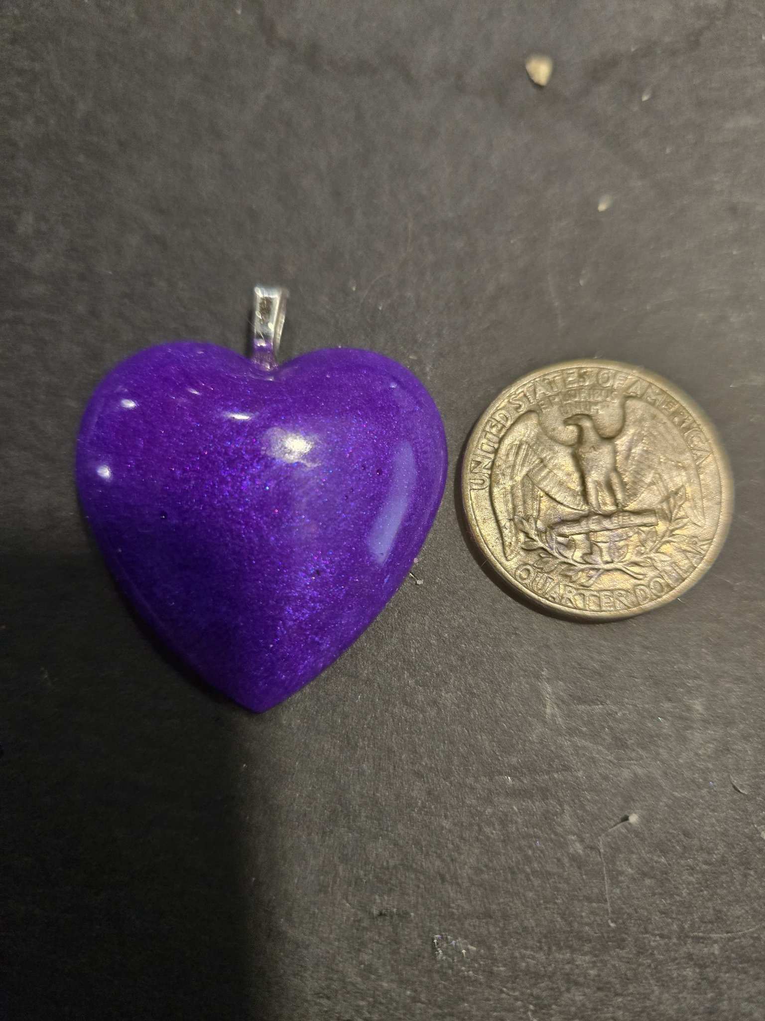 Stock 247 purple heart pendant beside a US quarter for scale