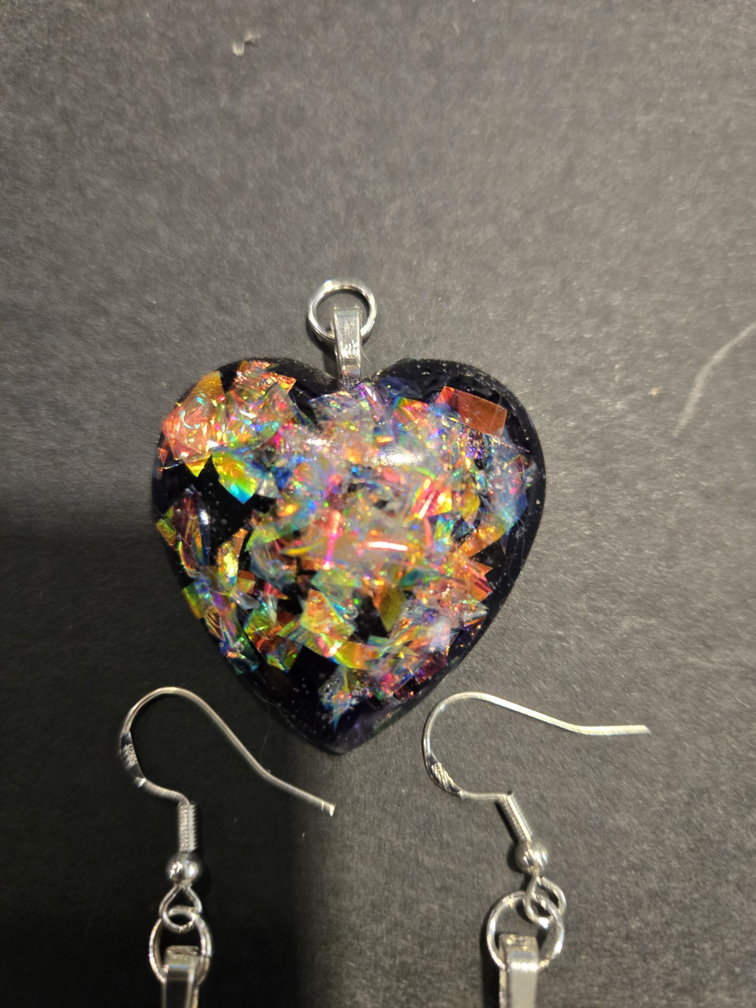 Close-up of the stock 248 holographic heart pendant, showing the rainbow holographic flakes against the black resin
