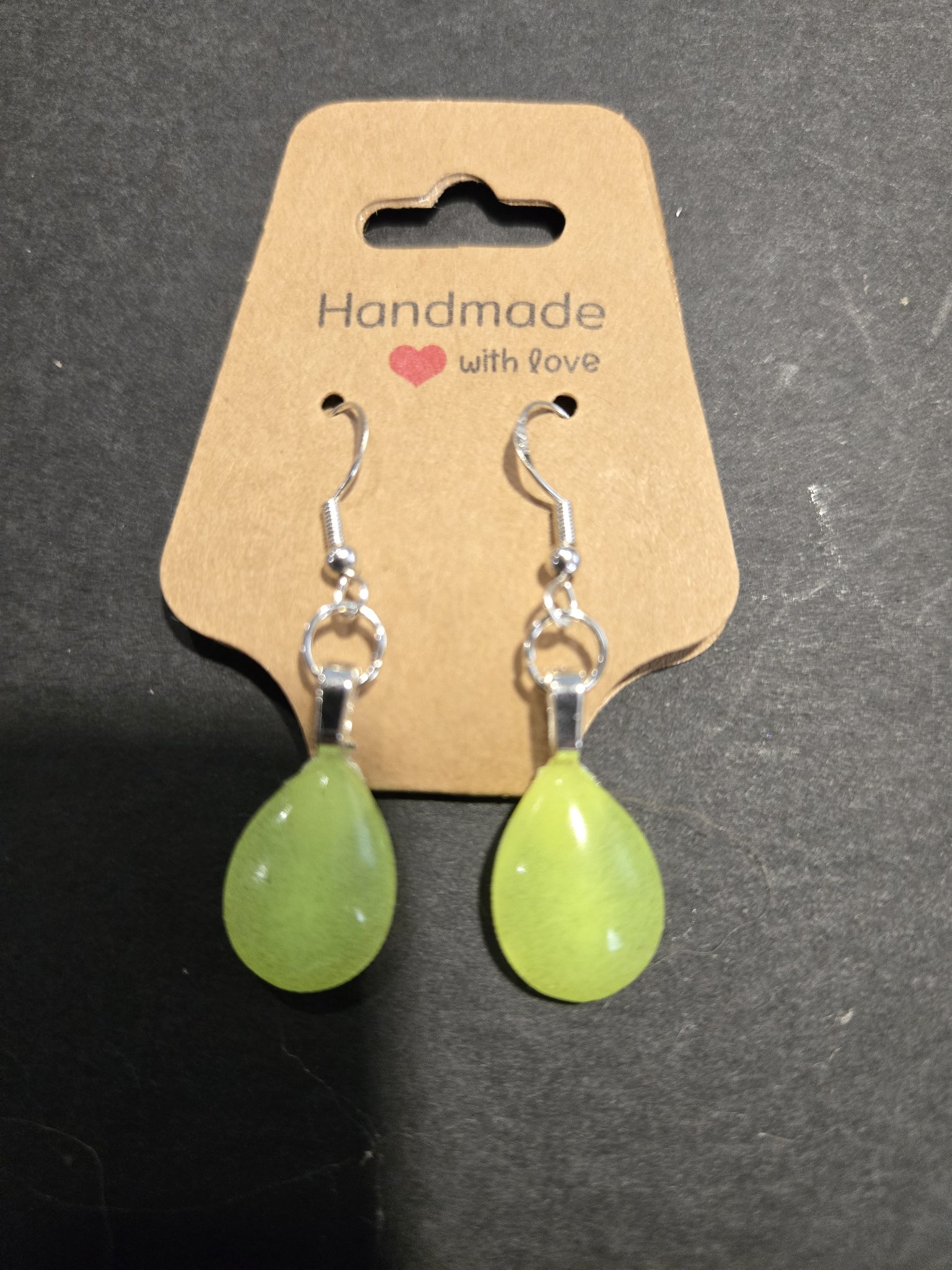 Stock 252 teardrop earrings in their pale green daylight color on a brown Handmade with love card