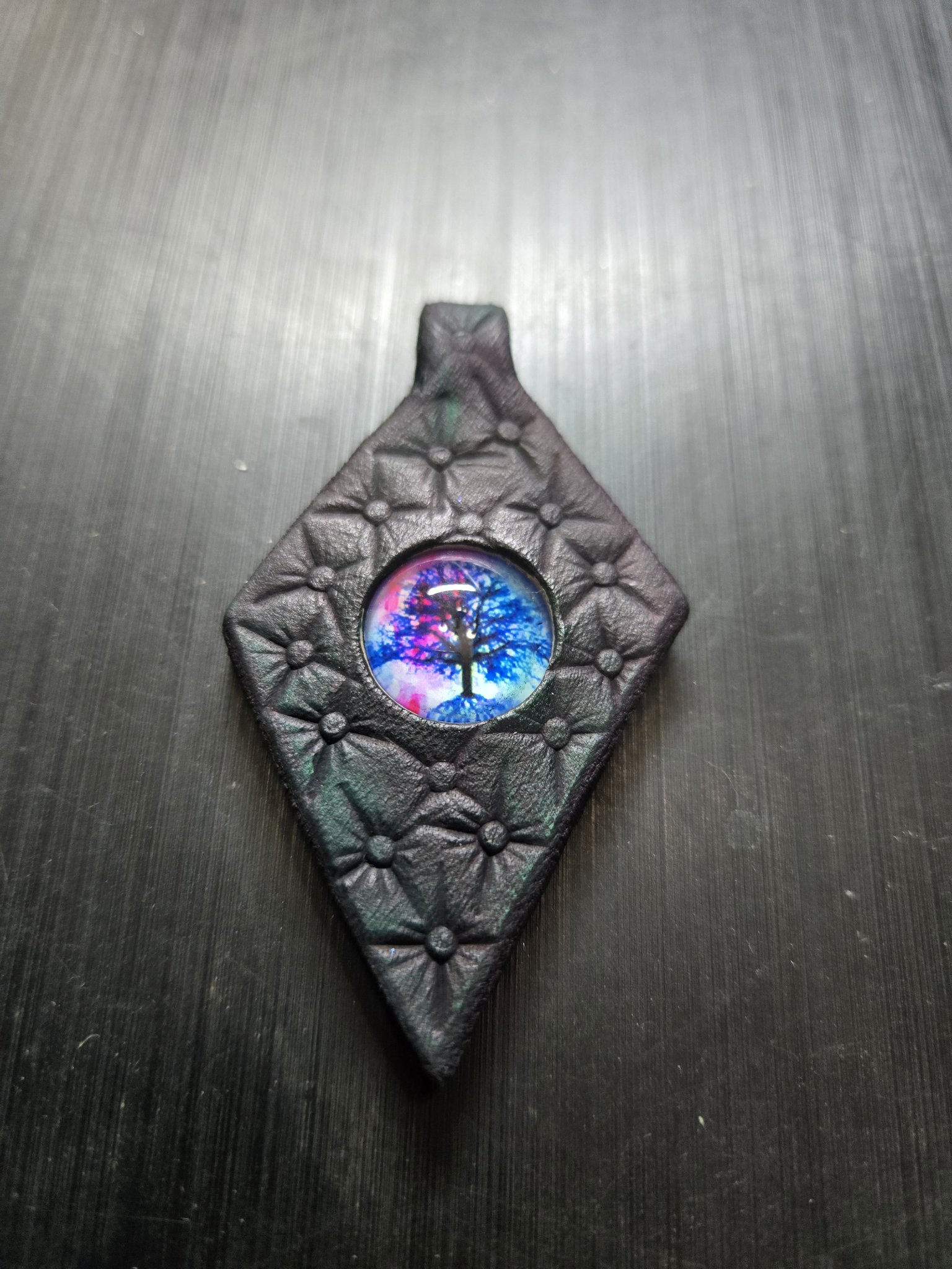 Stock 157 diamond-shaped black leather pendant with star stamping and a blue, pink, and purple glass Tree of Life cabochon