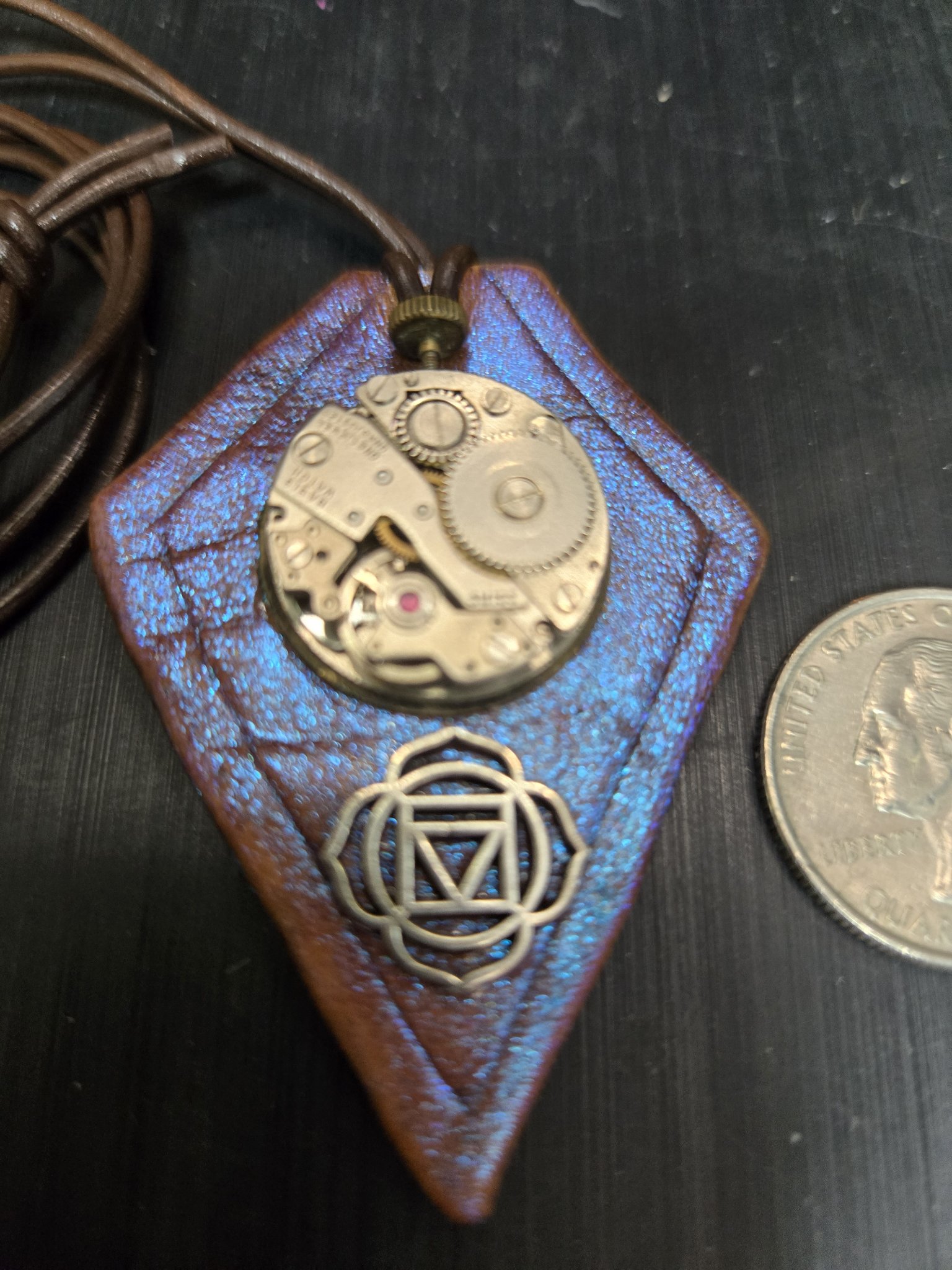Stock 158 purple leather watch movement pendant beside a quarter for scale