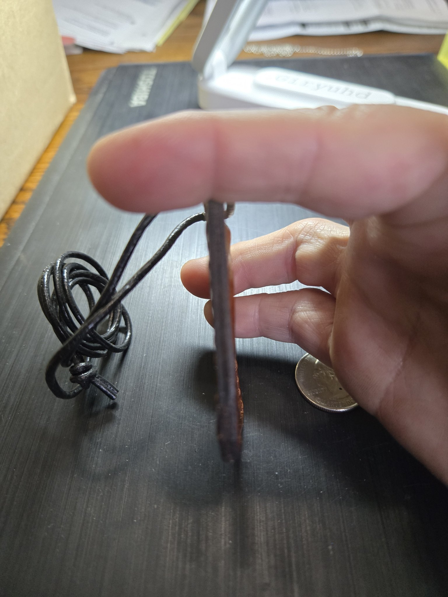 Side view of stock 159 brown leather watch movement pendant held in hand