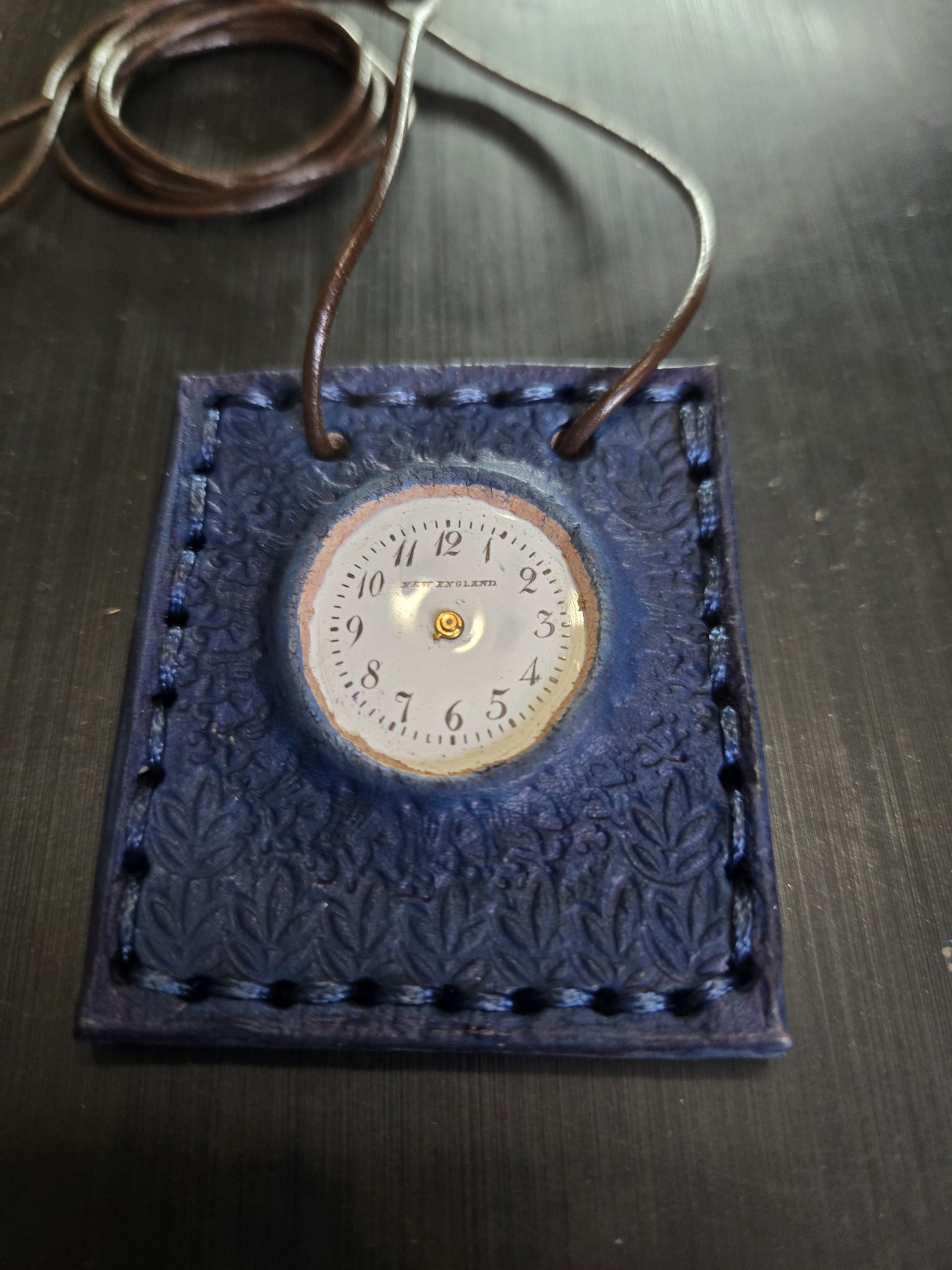 Angled front view of stock 163 showing the vintage New England clock face decoration and stamped blue leather