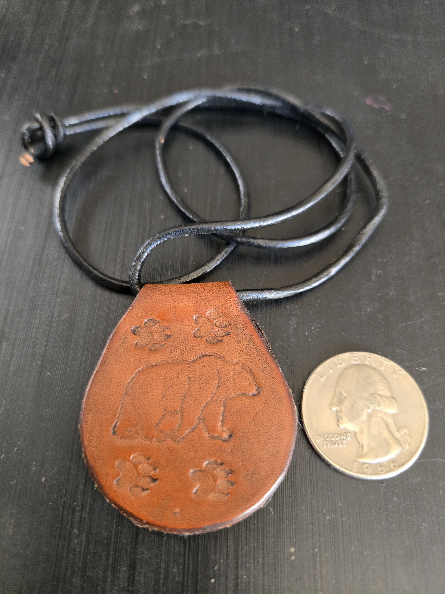 Stock 176 Grizzly Bear Leather by D. Guy pendant beside a quarter for scale