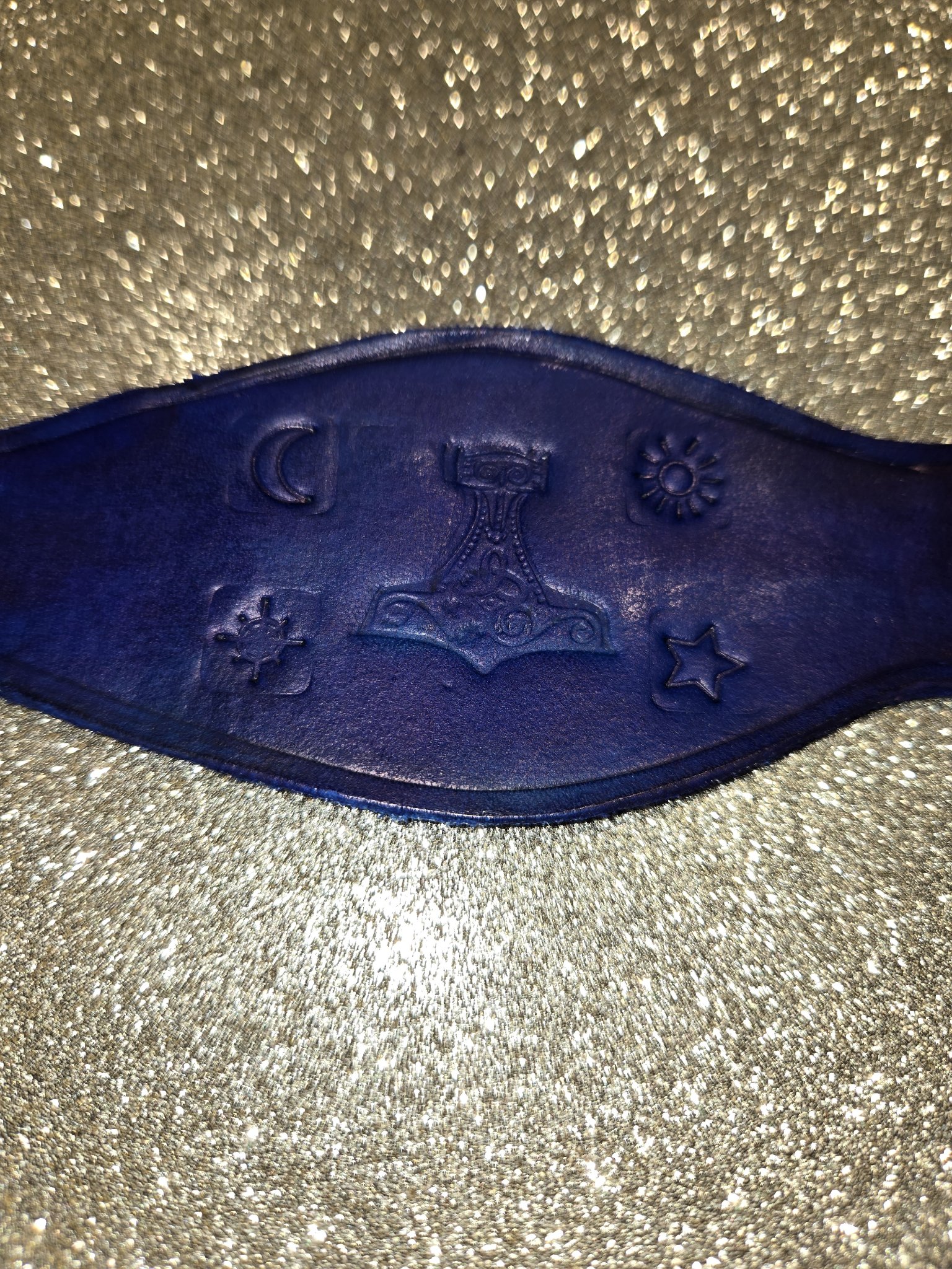 Close-up of the Thor's hammer, sun, moon, star, and compass stamped into stock 210 leather cuff