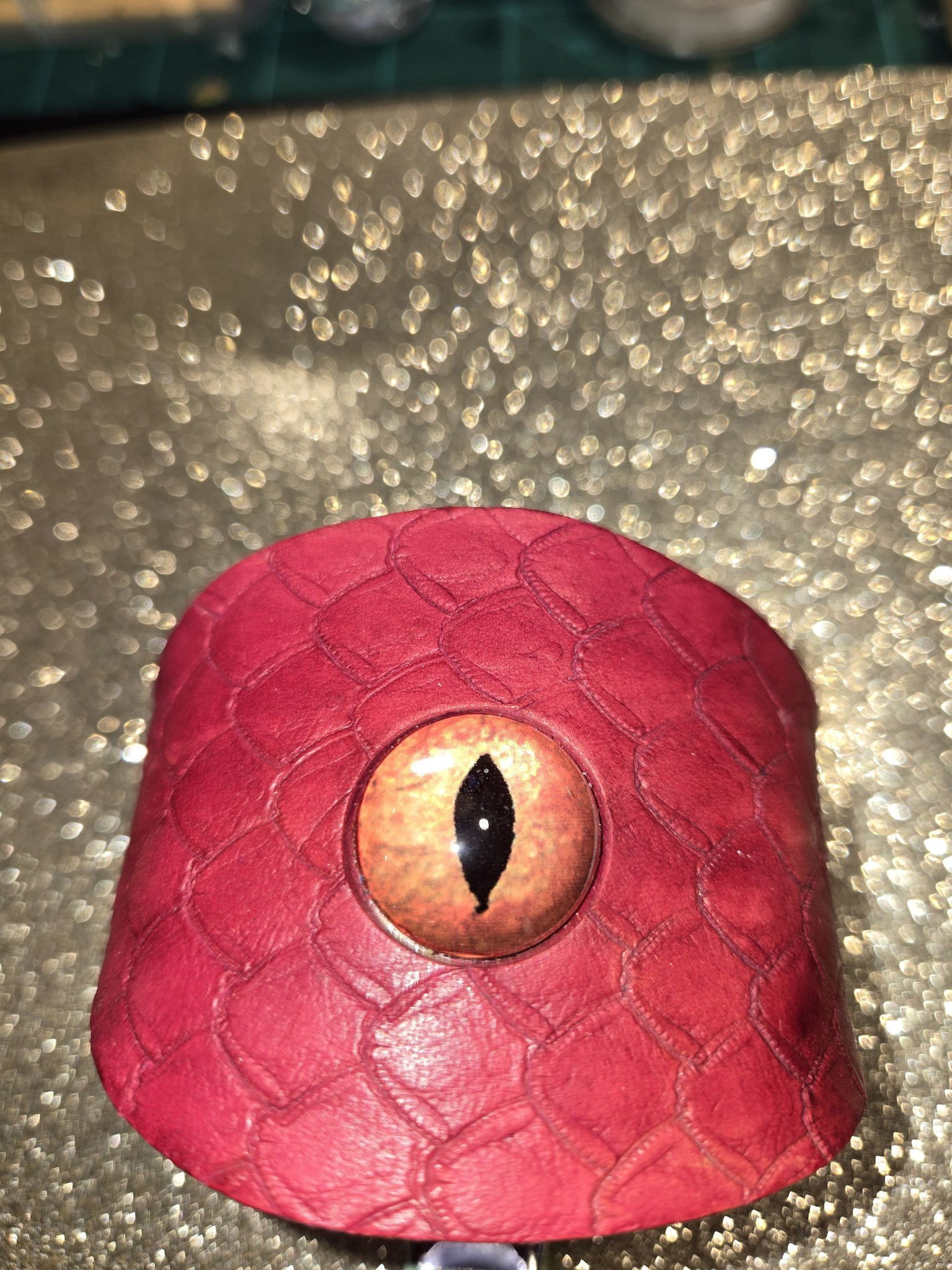 Close-up of the dragon eye and scale pattern on stock 212 red leather cuff