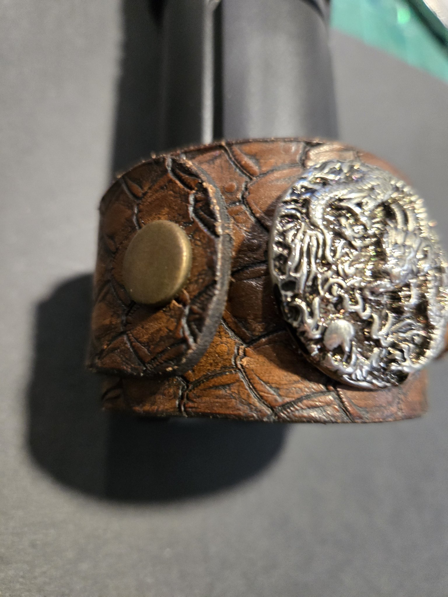 Close-up of the silver-tone dragon emblem and bronze snap on stock 214