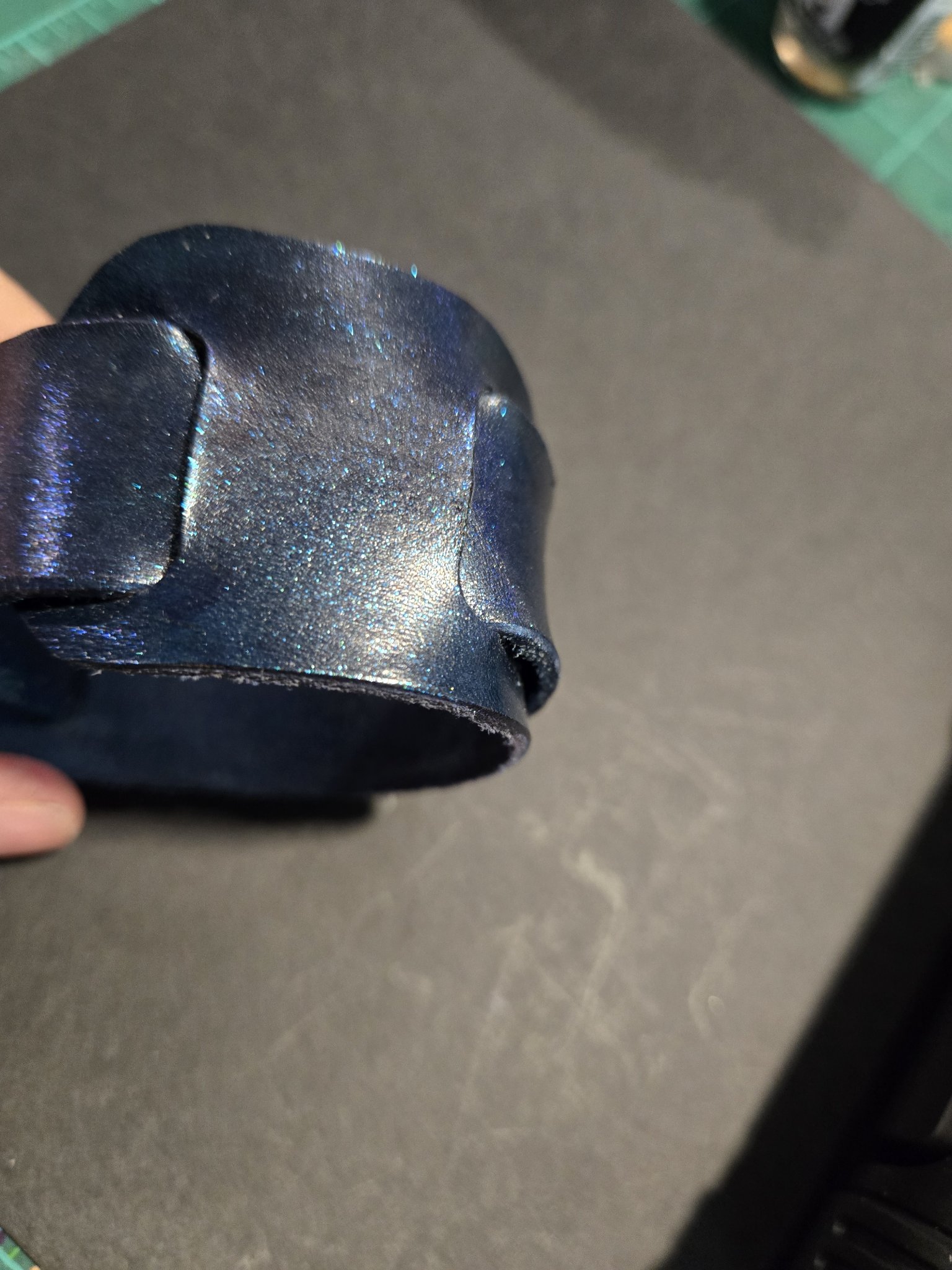Side view of stock 224 showing the layered cuff shape and purple sheen
