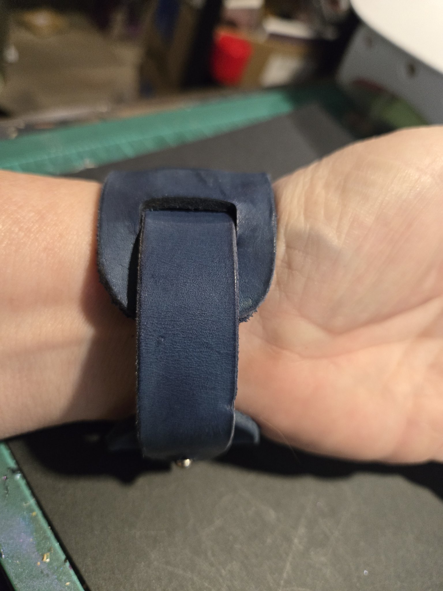 Underside view of stock 225 on a wrist showing the wrap strap and button stud