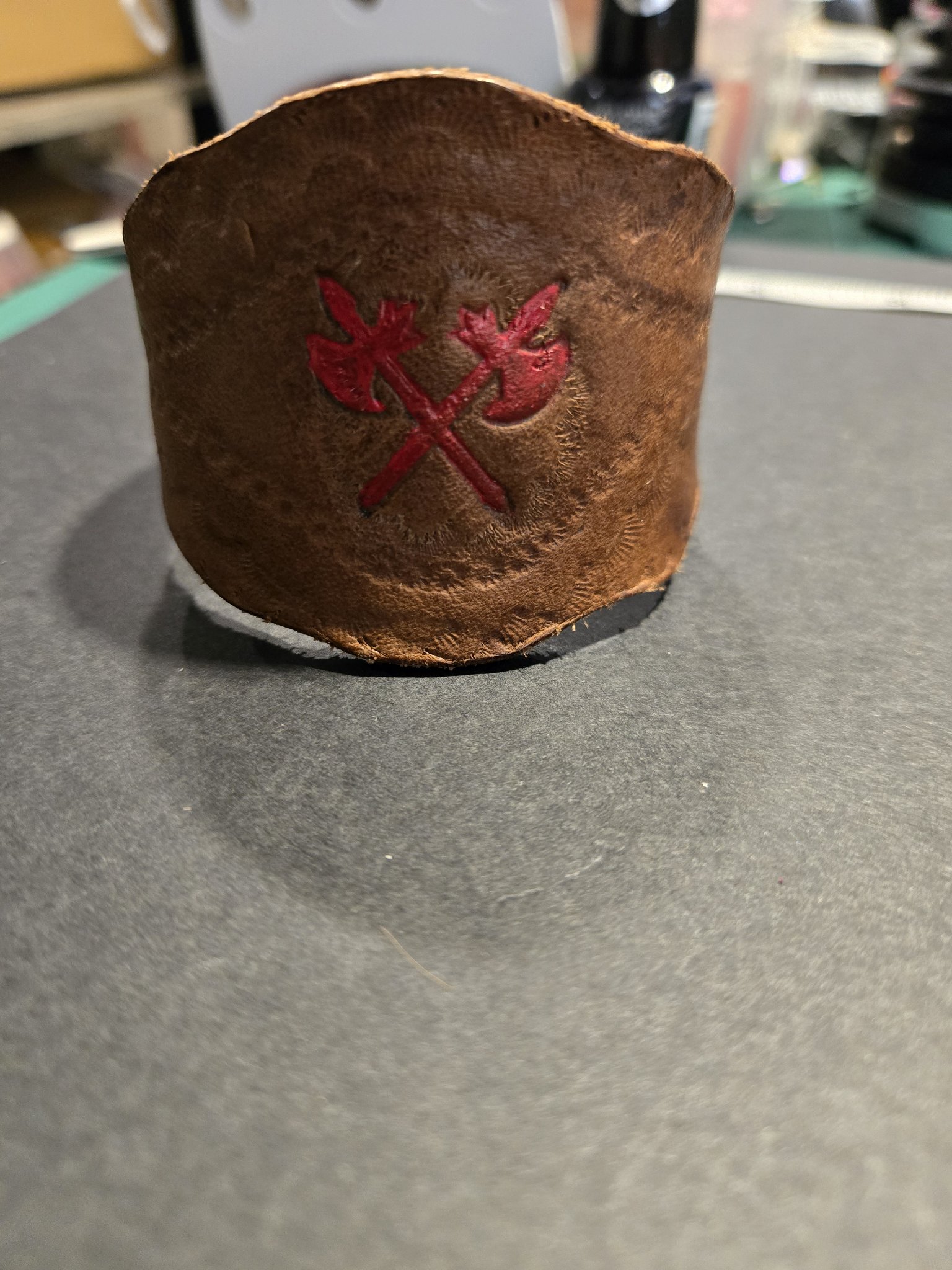 Front view of stock 230 standing showing its wide brown leather band and red crossed axes