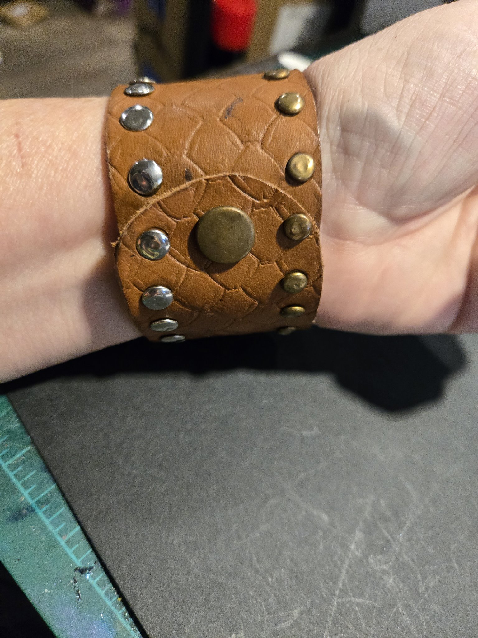 Stock 231 on a wrist showing its snap closure and studded scale-pattern band