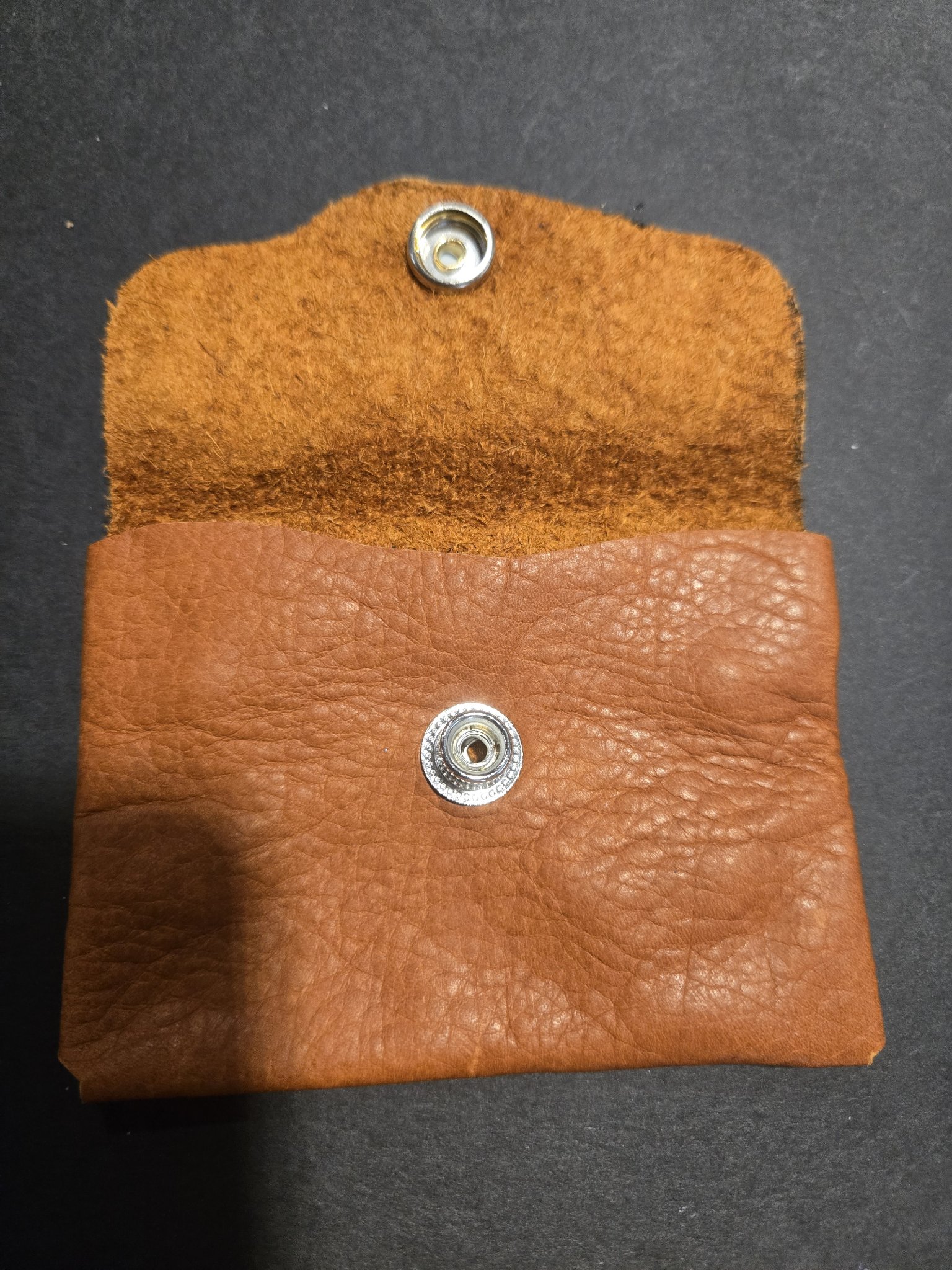 Stock 243 held open with the flap raised, showing the soft suede underside of the flap and the silver-tone snap closure