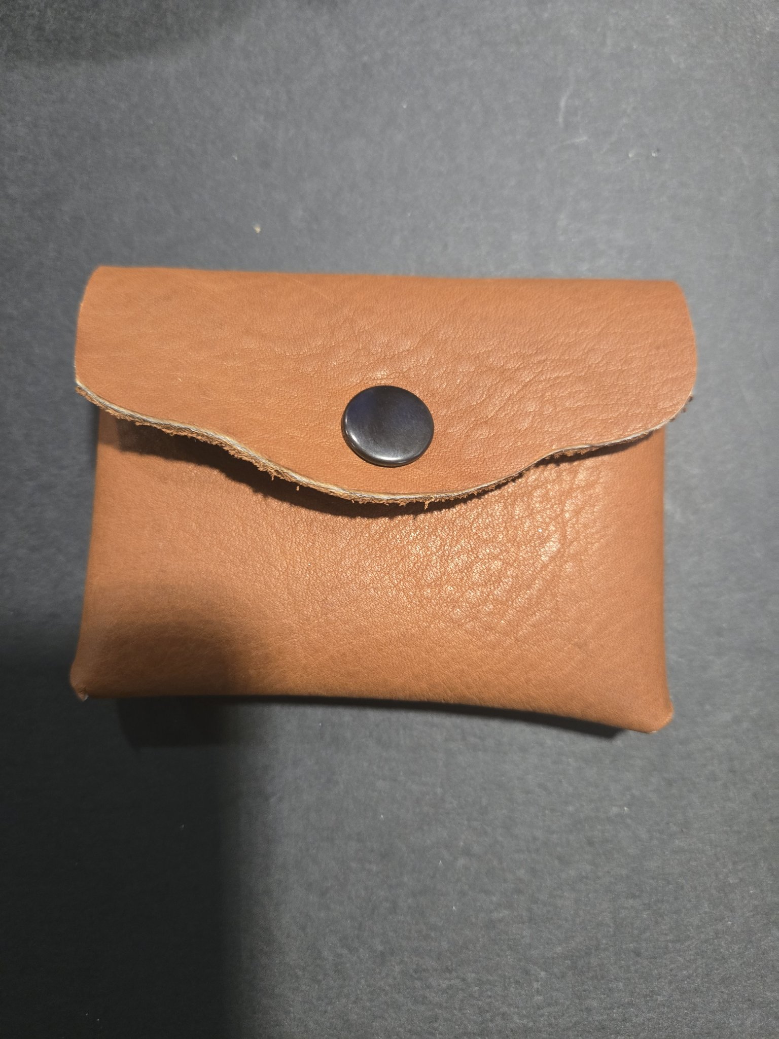 Stock 244 thick beefy cowhide leather card and money holder closed, showing the envelope-style flap and black snap closure